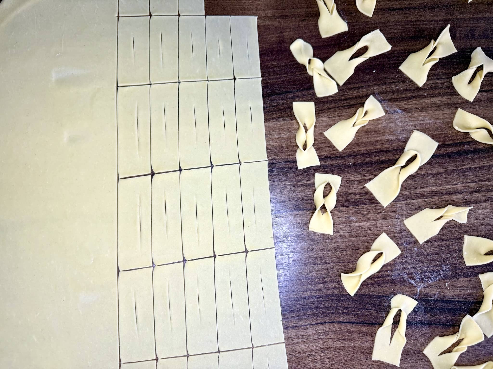 Cutting rectangles from dough and twisting them into the shape of angel wings