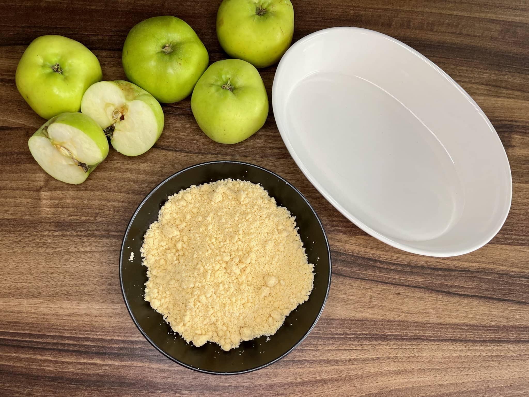 Apples, Baking Dish and ready crumble on tabletop