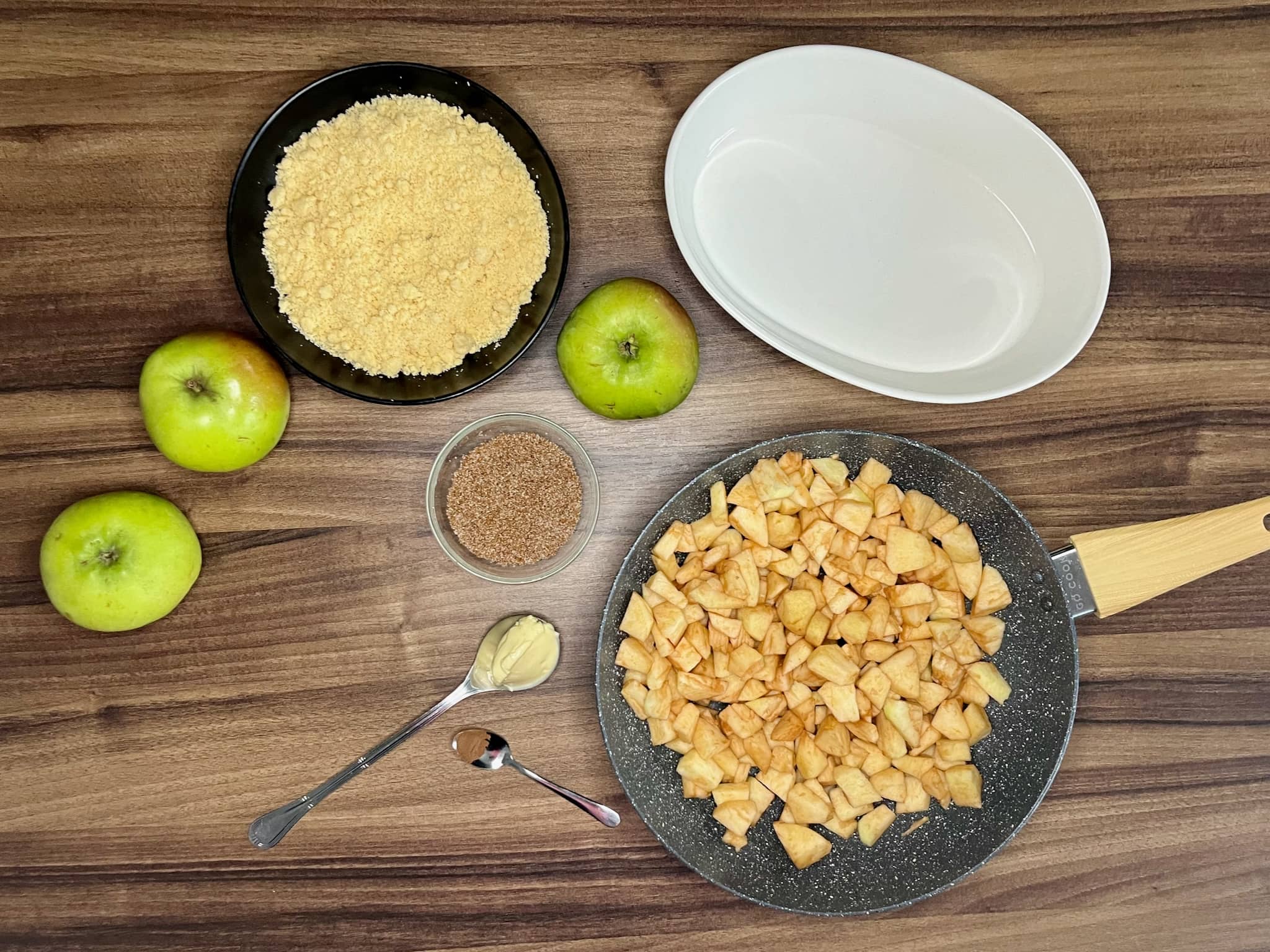 Sliced apples in a pan, Baking Dish and ready crumble on tabletop