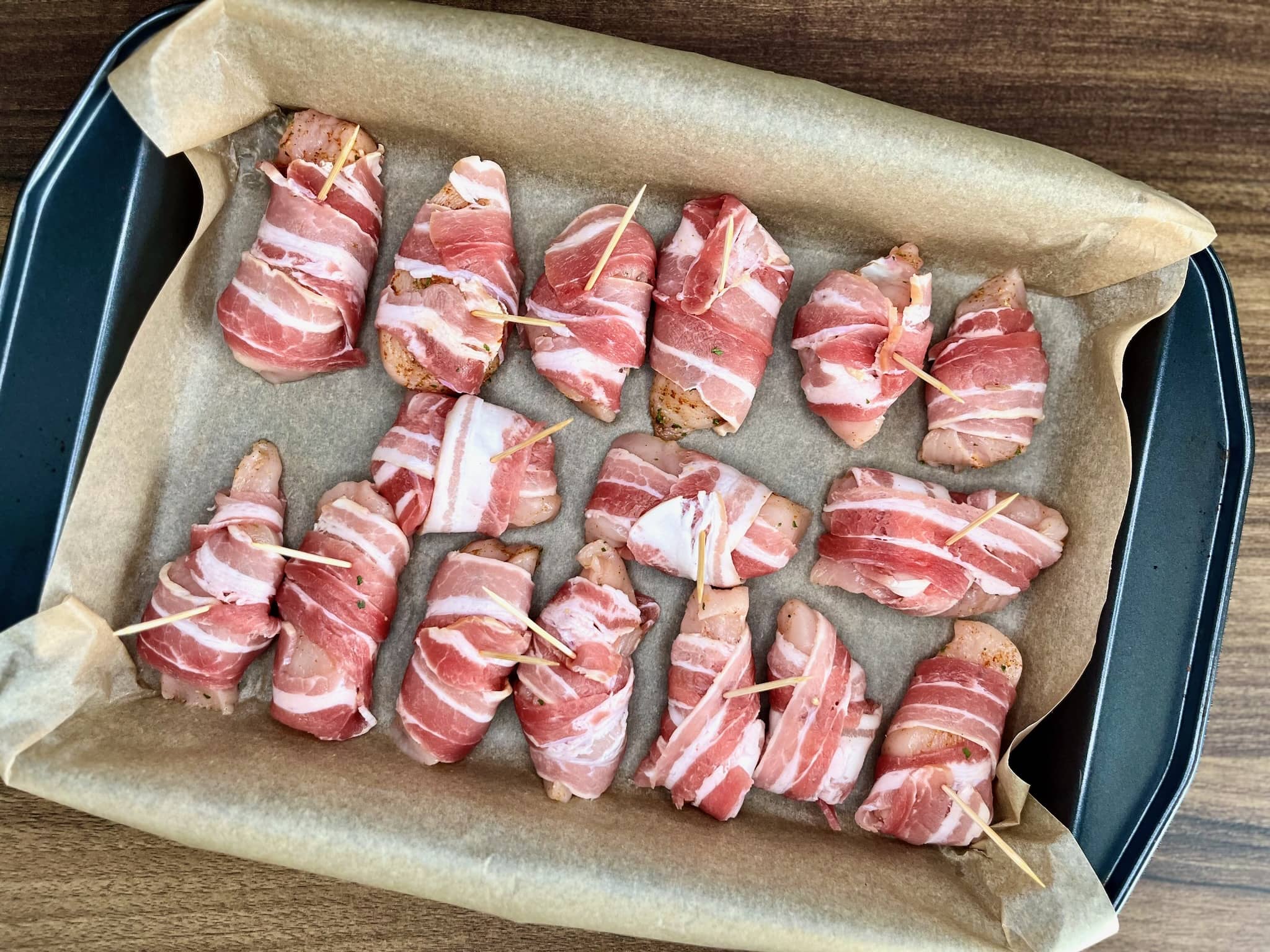 Bacon-wrapped chicken bites, ready for baking, await their transformation into crispy, flavorful appetizers