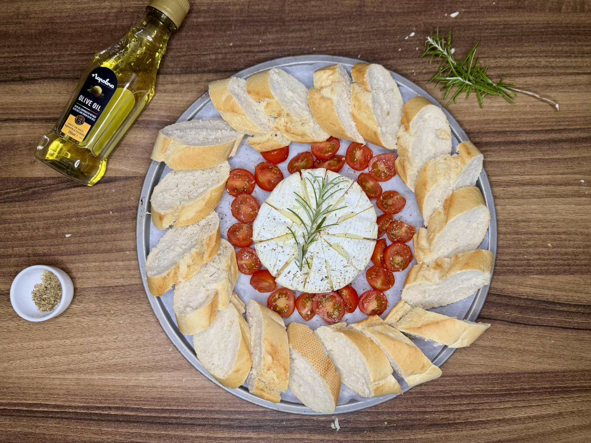 Tray arranged with baguette slices before adding herbs and drizzling with olive oil