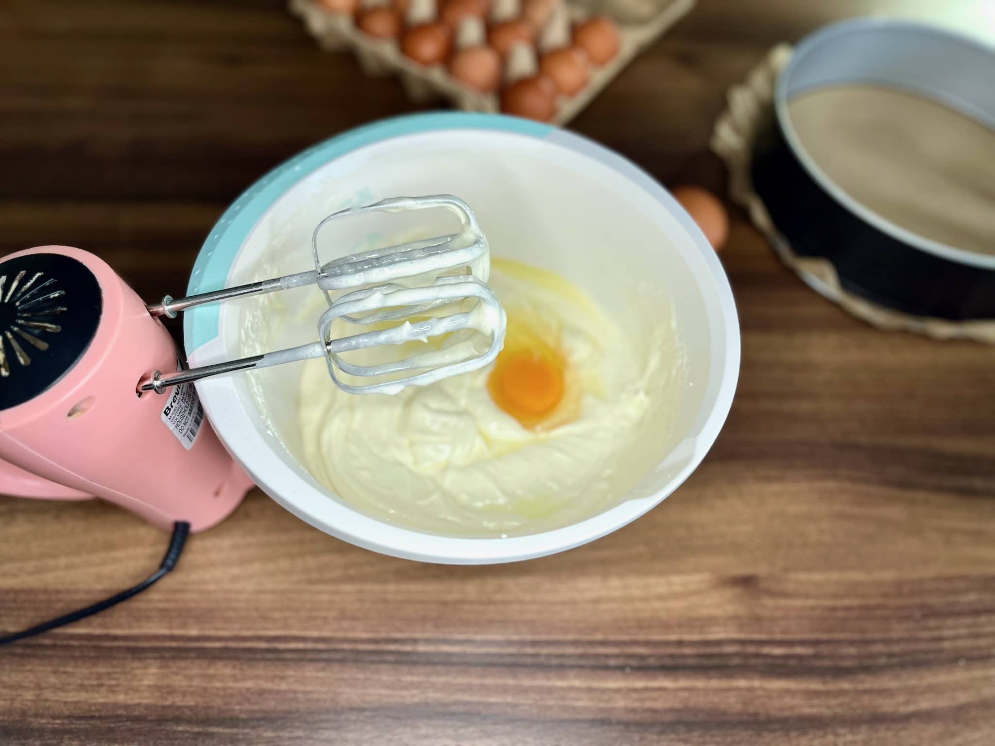 Soft cream cheese beaten with an egg in a mixing bowl