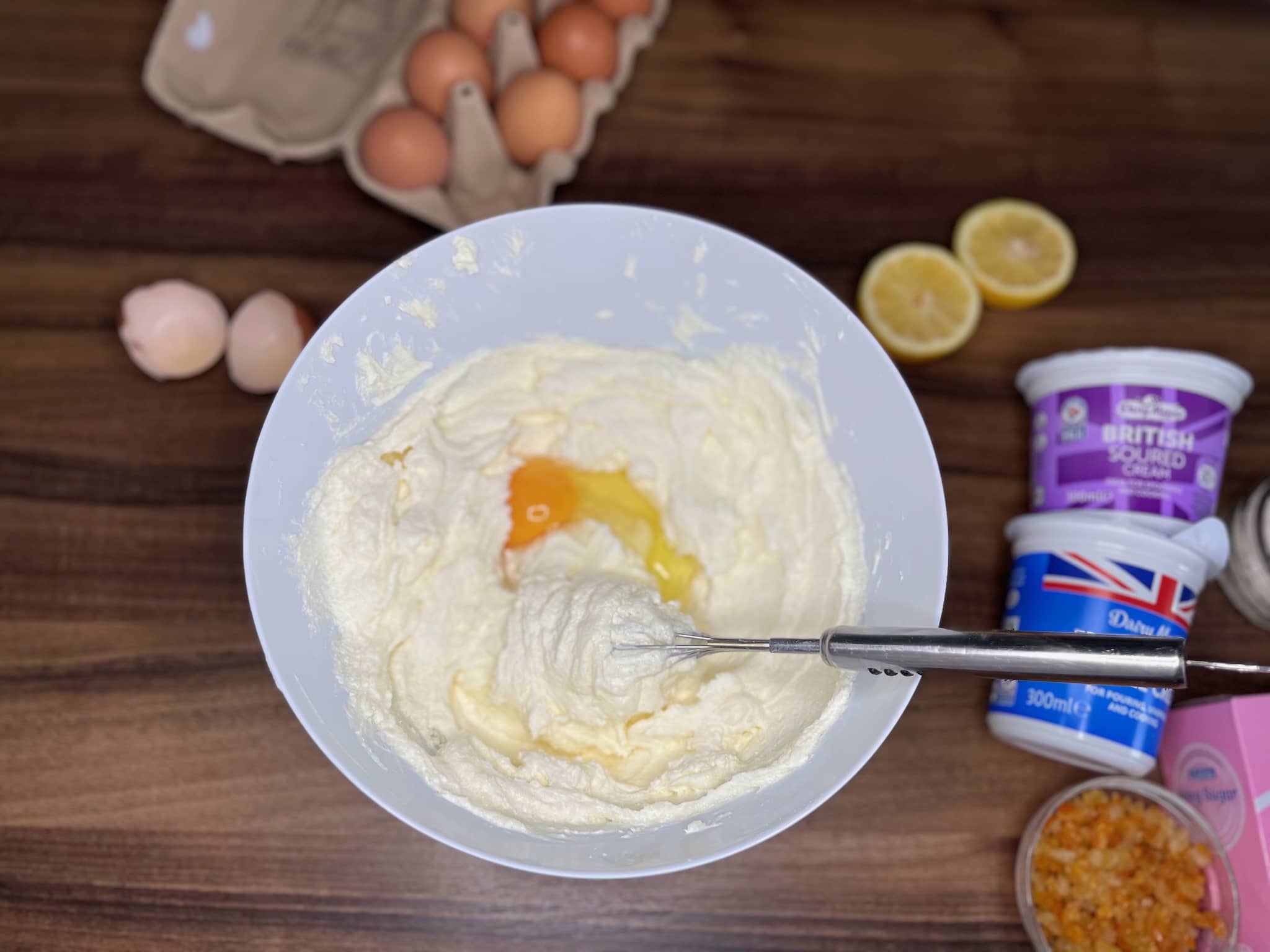 Mixing cream cheese mixture in a bowl with added egg