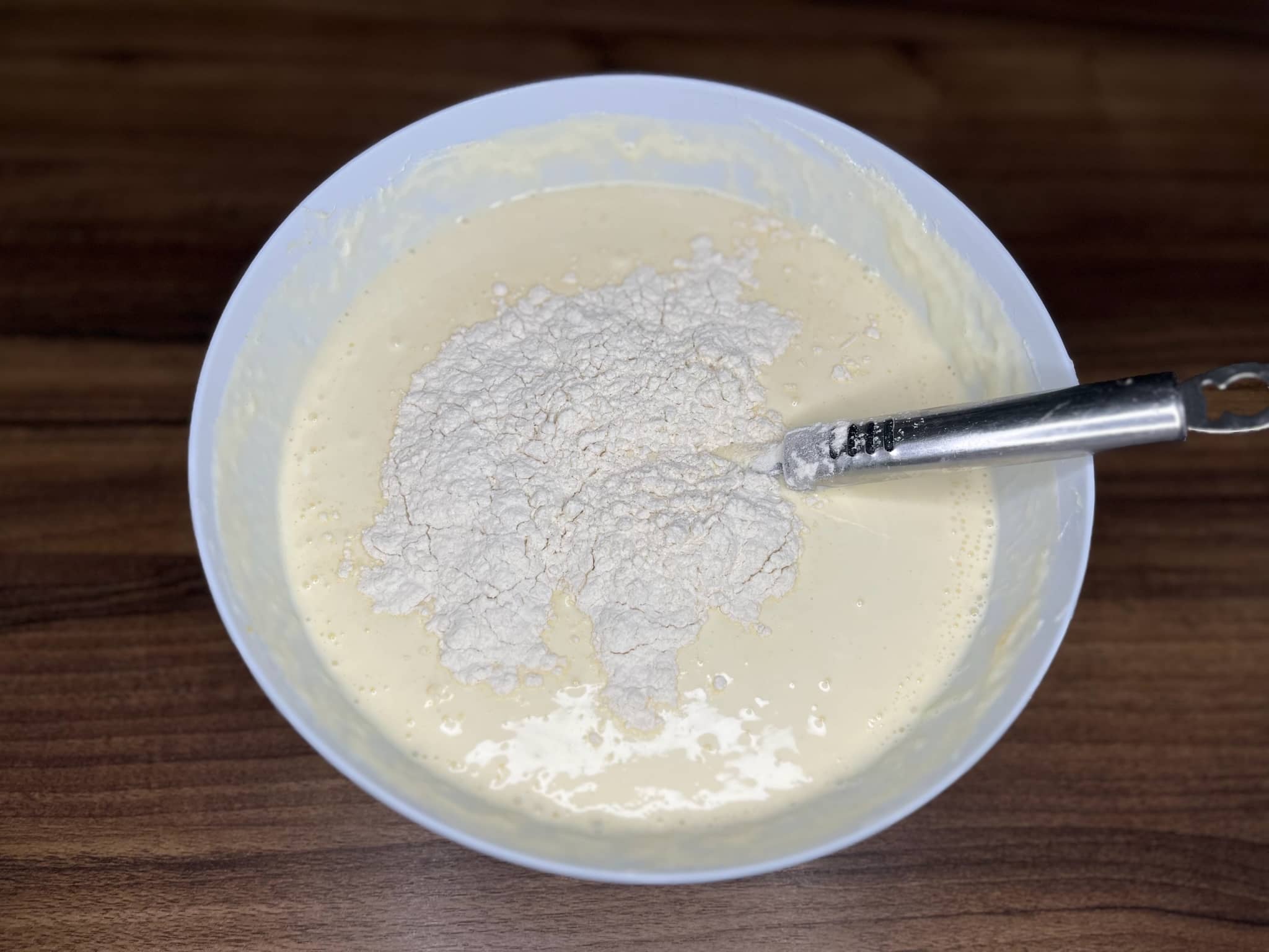 Cheesecake mixture in a bowl with added flour