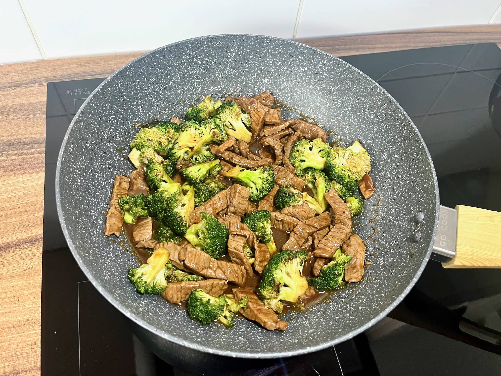 Beef and broccoli stir-fry in a pan with added sauce