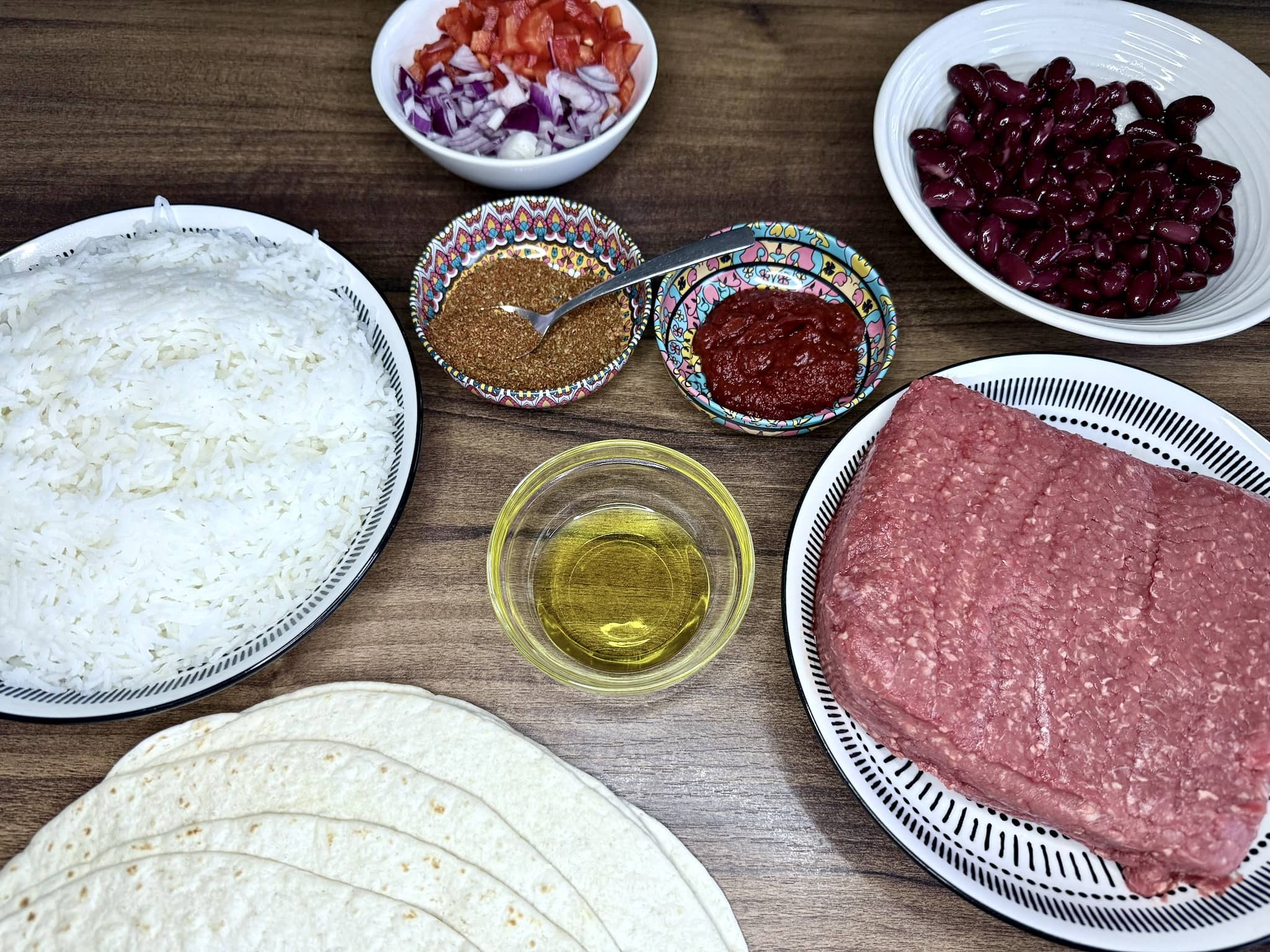 All the ingredients on a tabletop, ready to make a Beef Burrito
