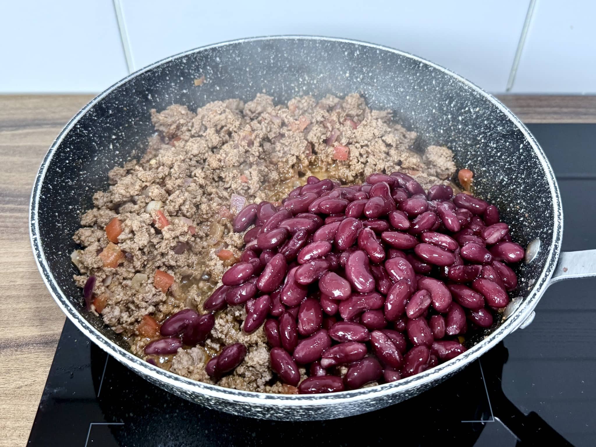 Red kidney beans added to the pan with the beef
