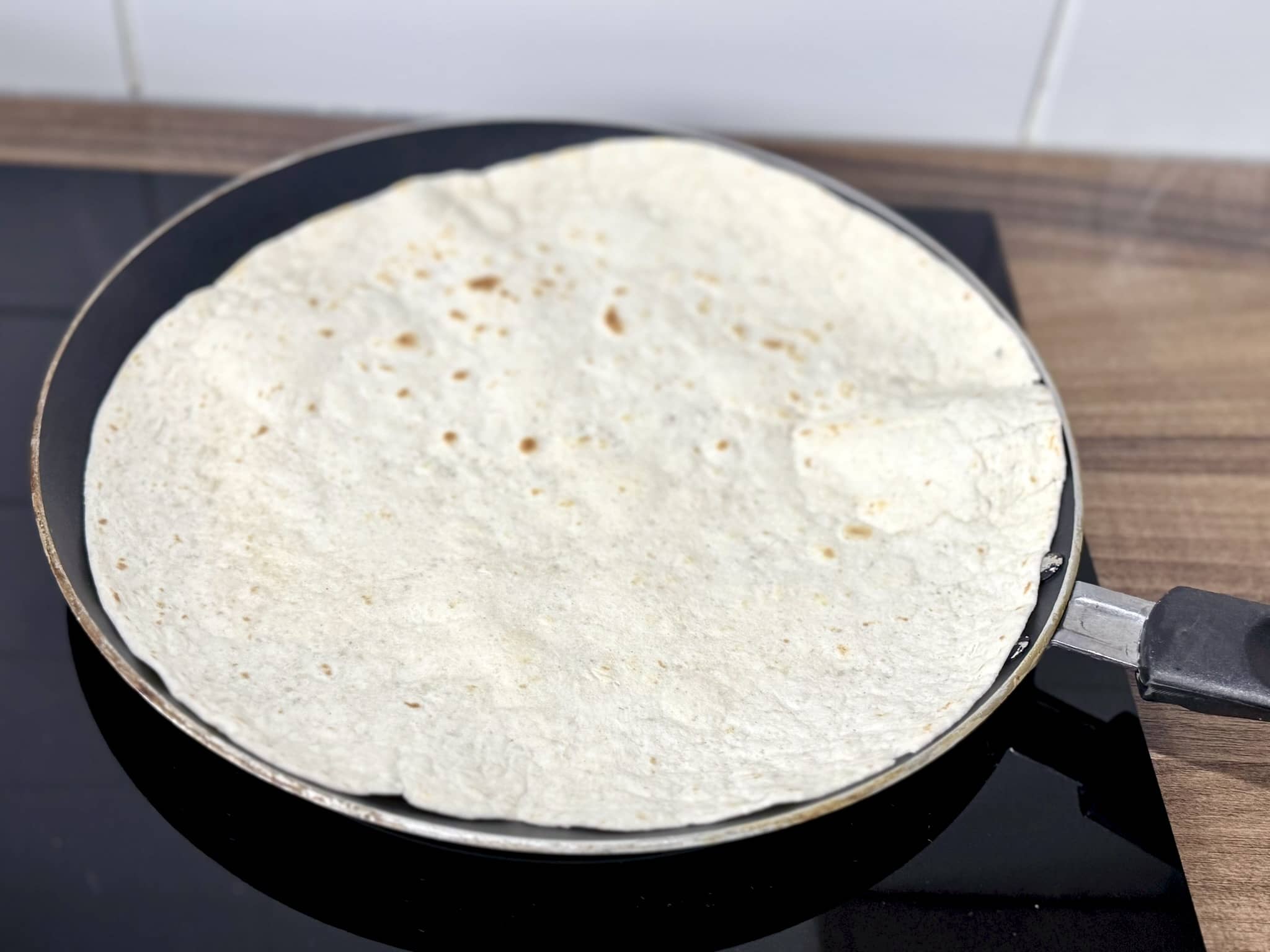 Tortilla wrap heating in a frying pan