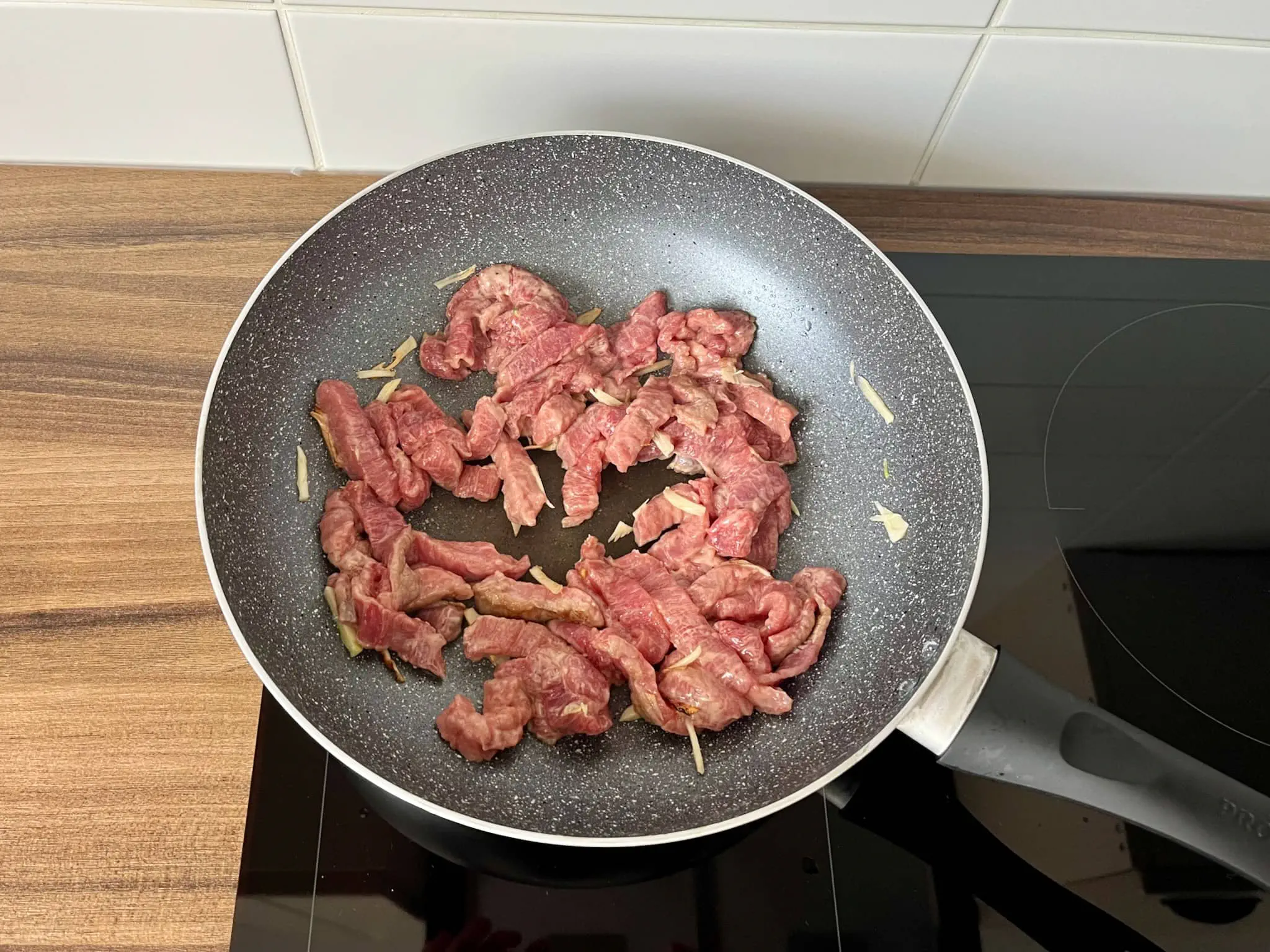 Wołowina i czosnek na patelni, gotowe do smażenia