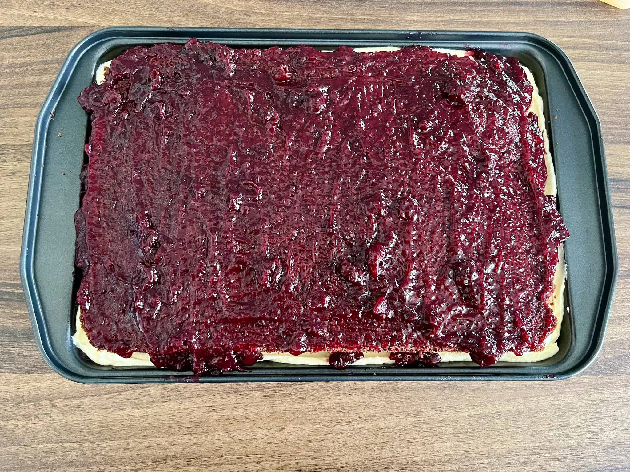Wierzchnia warstwa biszkoptu pokryta dżemem porzeczkowym