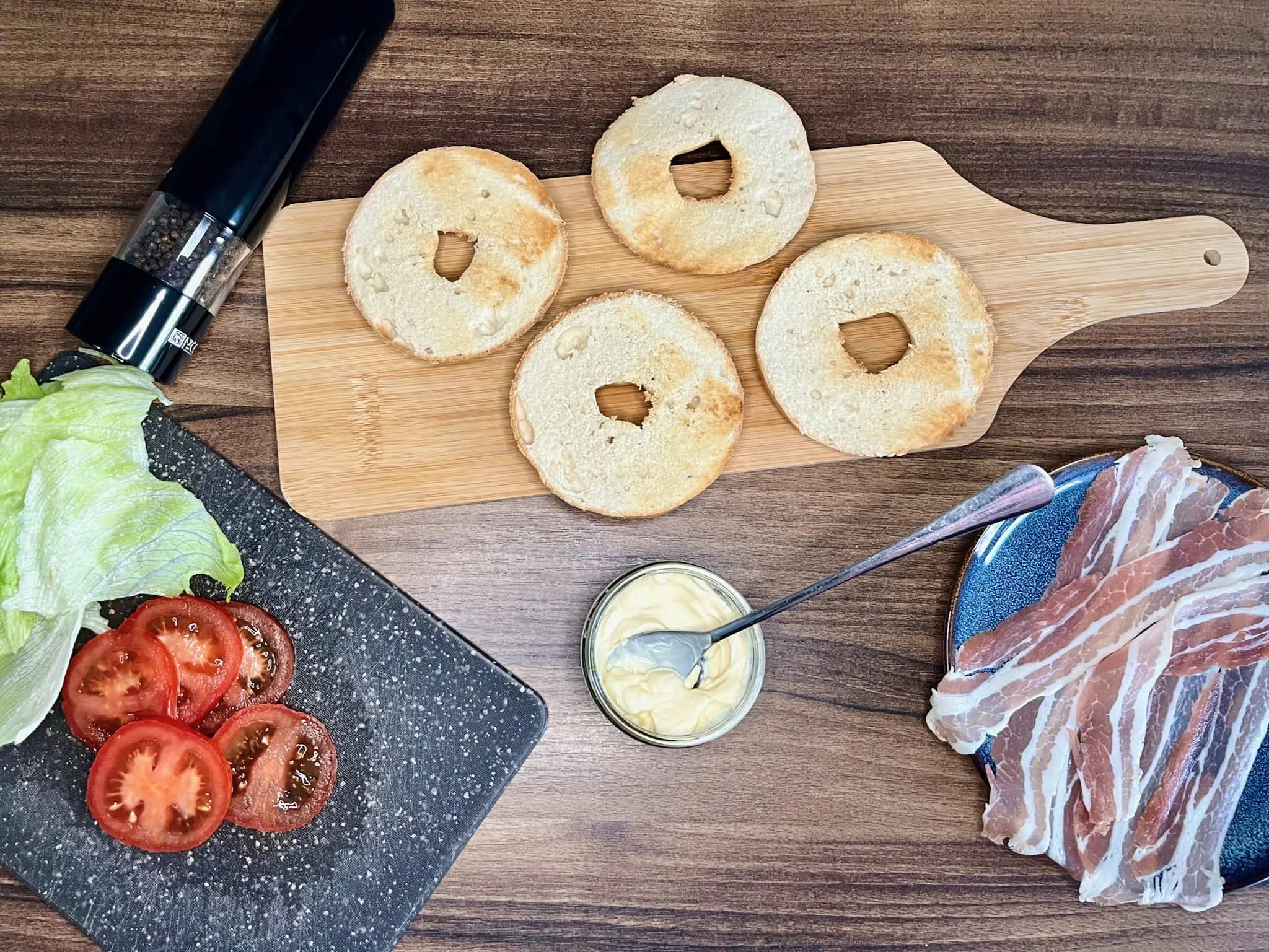 All the ingredients are on the table, ready to make BLT bagel sandwiches