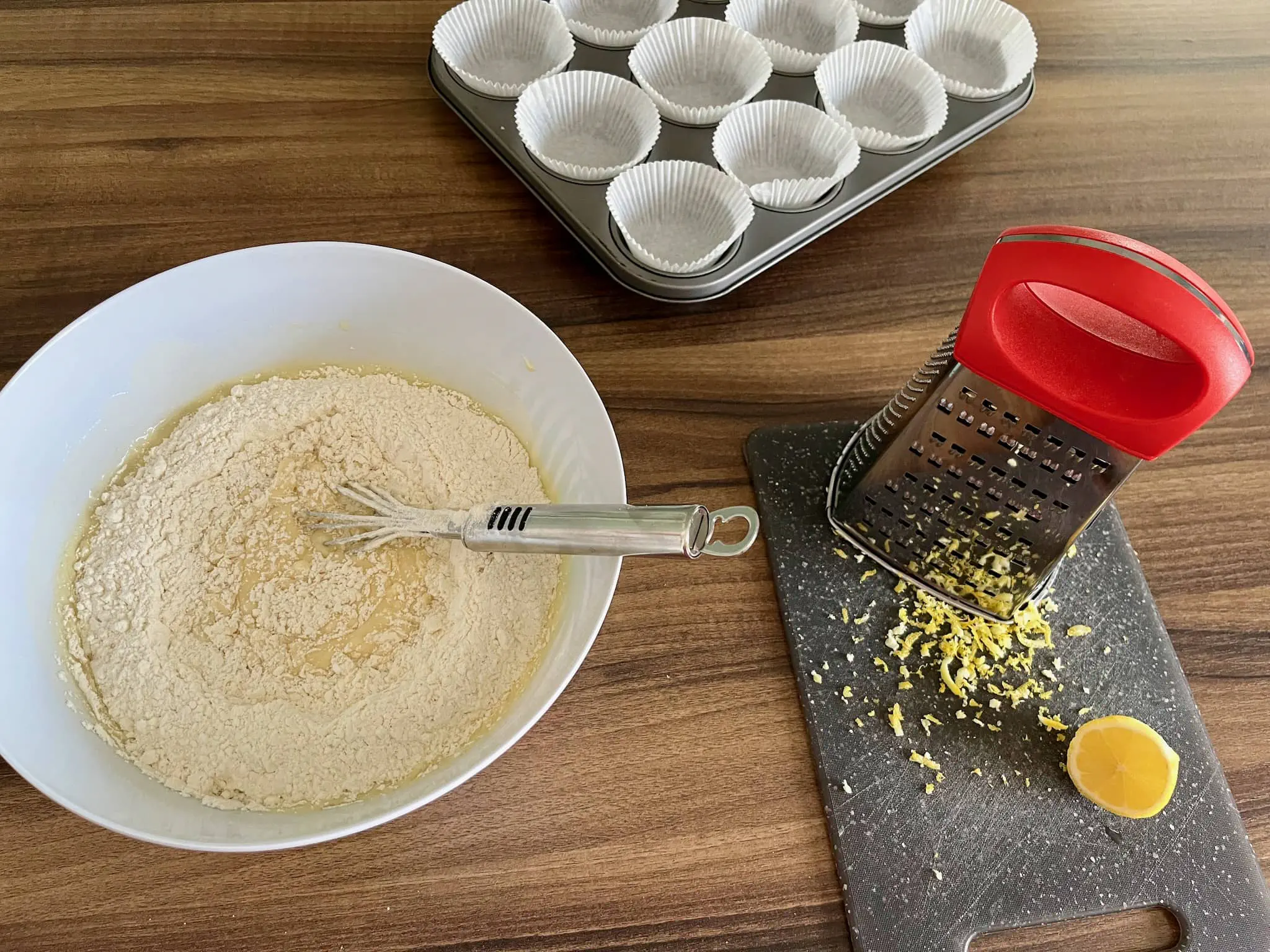 Lemon sested, cupcake cases ready and mixture in a bowl ready for mixing