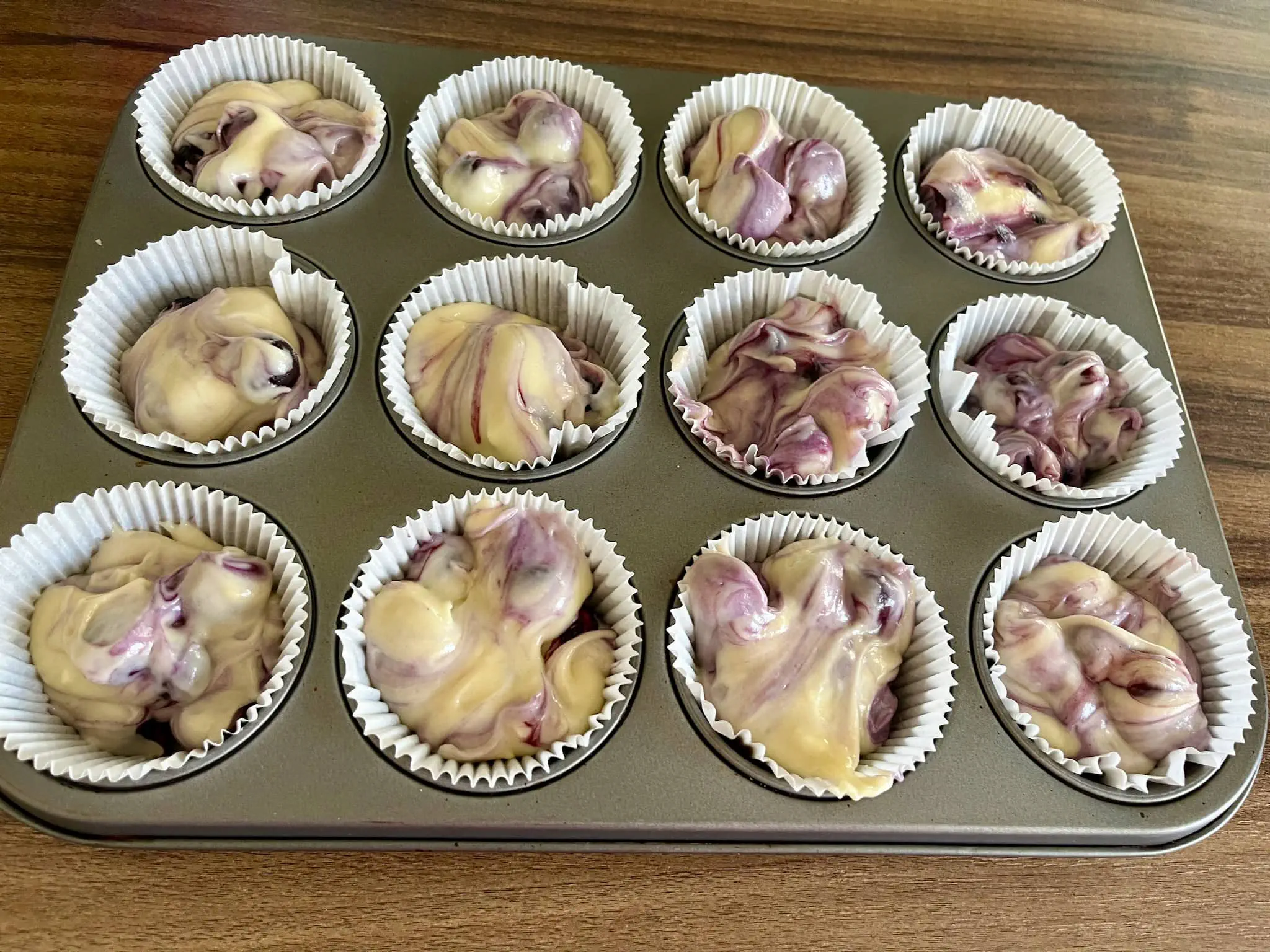 Blueberry muffin mixture scooped into cupcake cases ready to bake