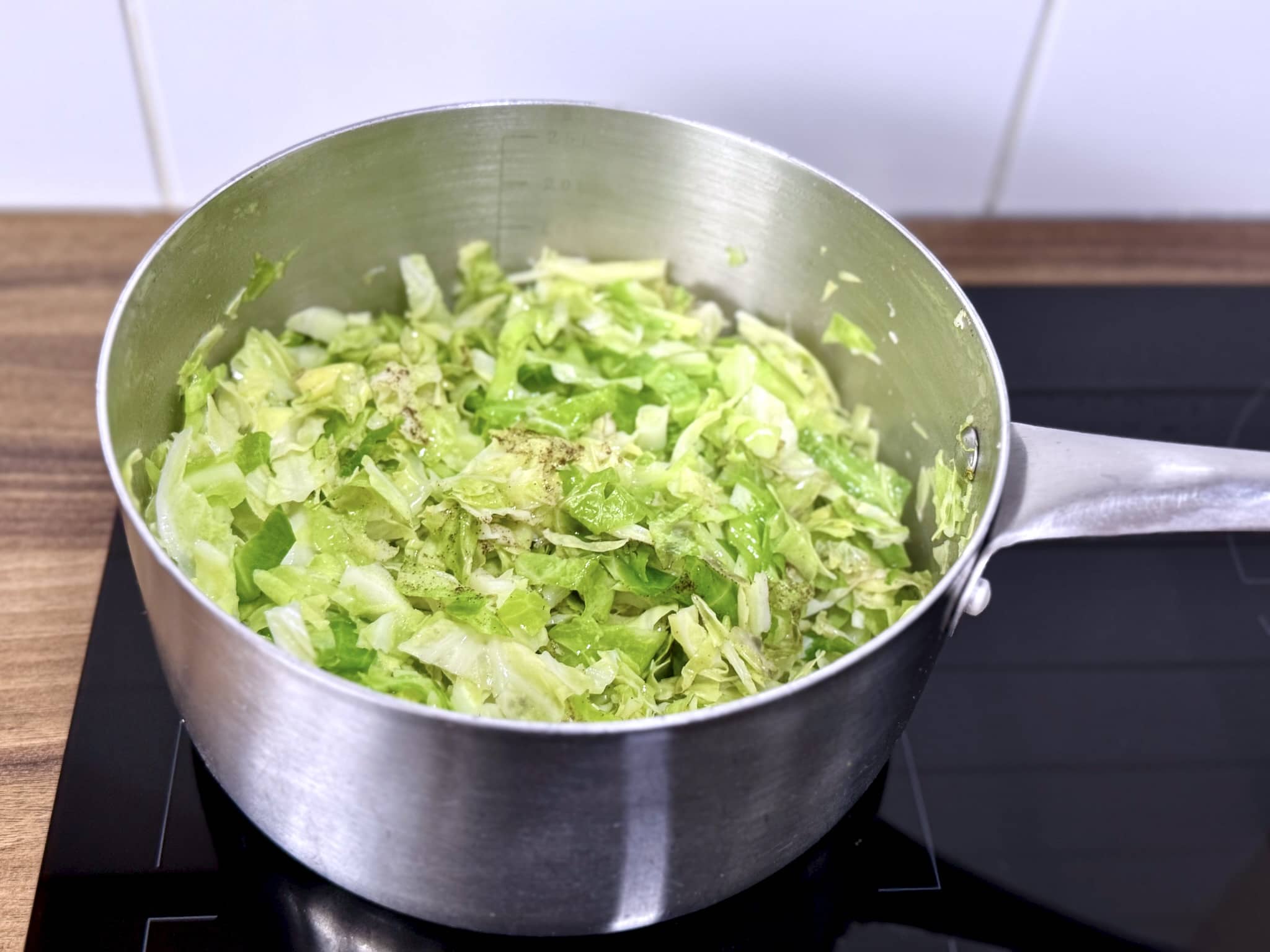 Cabbage sautéing in a pan with spices