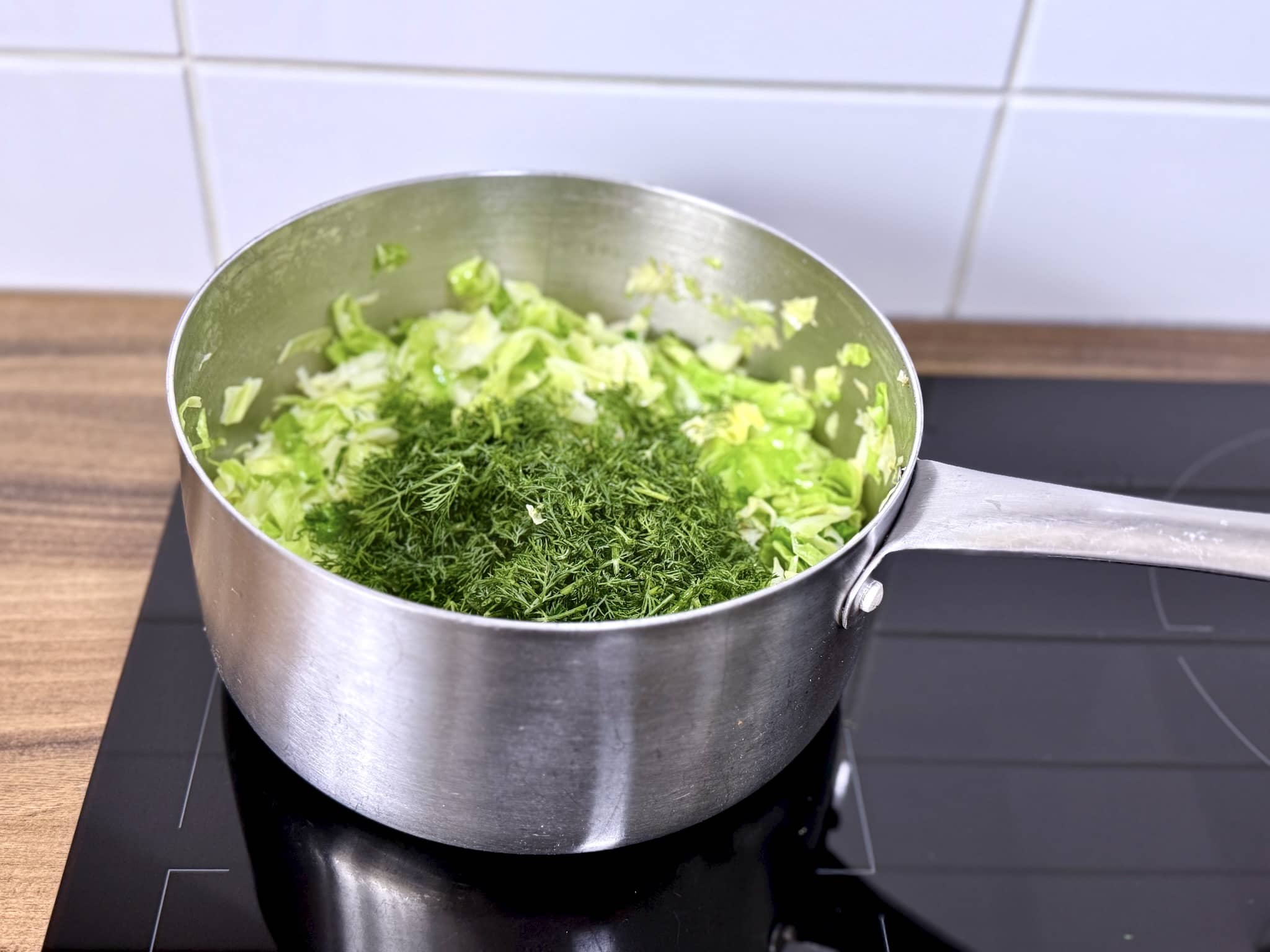 Cabbage sautéing in a pan with added dill