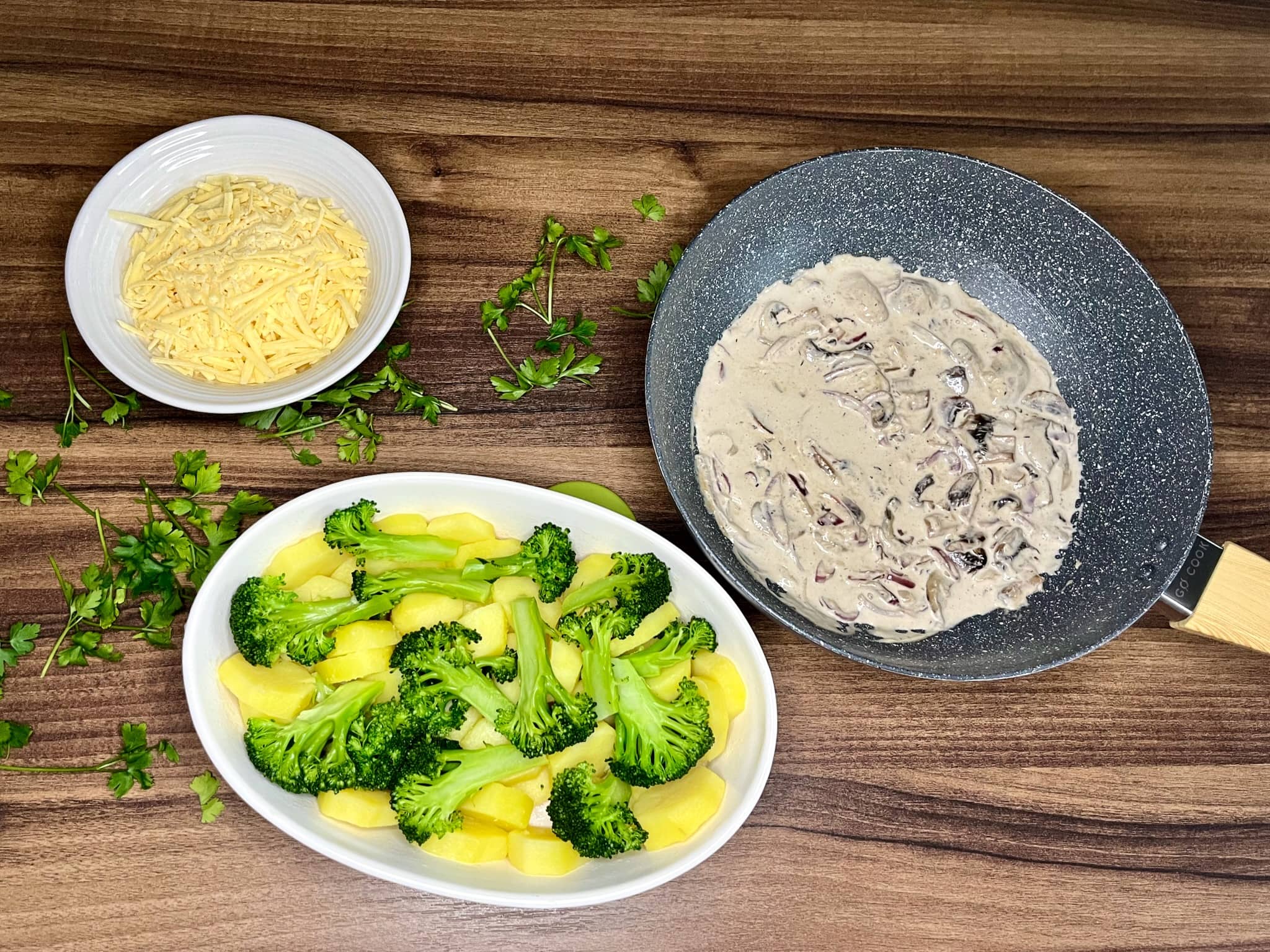 Potatoes and broccoli placed at the bottom of an ovenproof dish