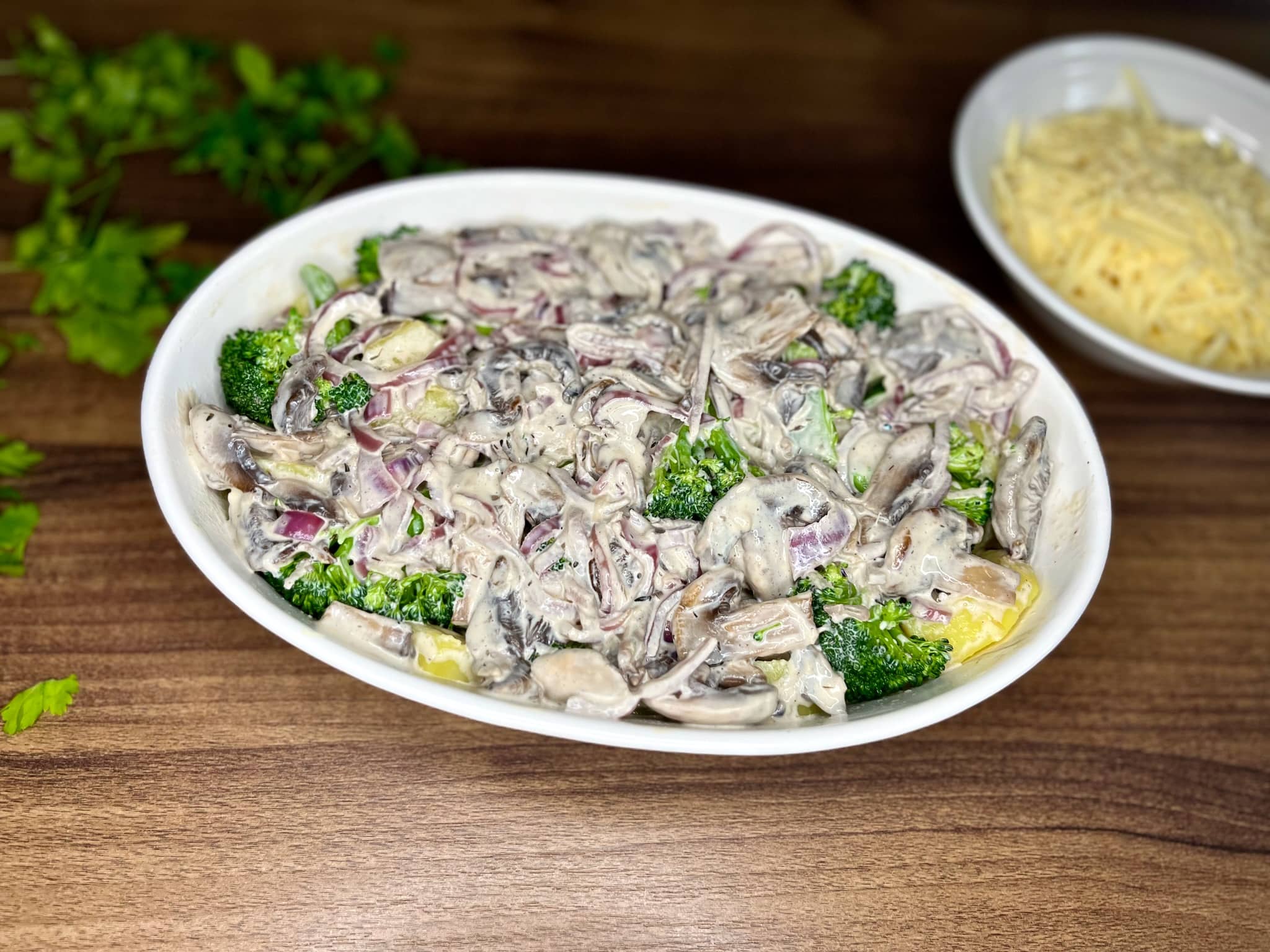 Mushroom sauce added on top of potatoes and broccoli in the ovenproof dish