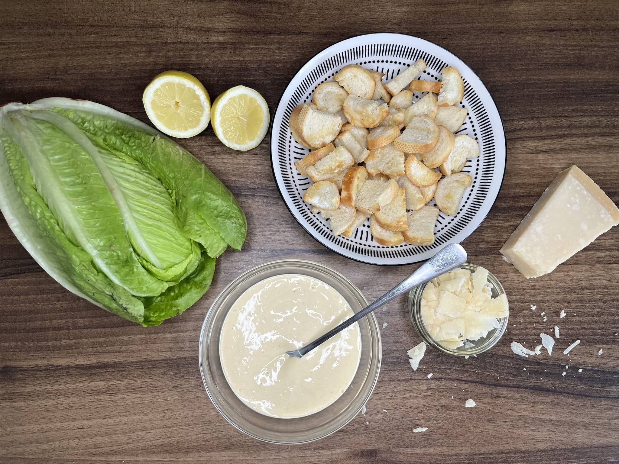 Homemade Croutons, Caesar Salad Dressing, and other ingredients on the table top ready to make Caesar Salad