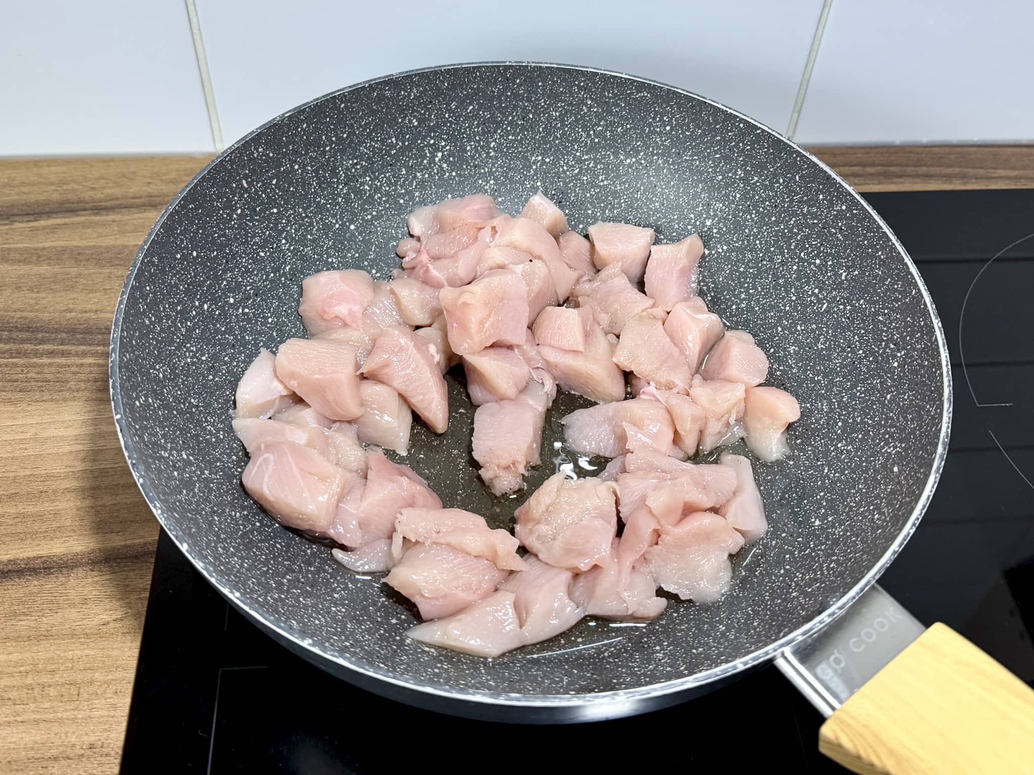 Pokrojone piersi z kurczaka smażące się na głębokiej patelni