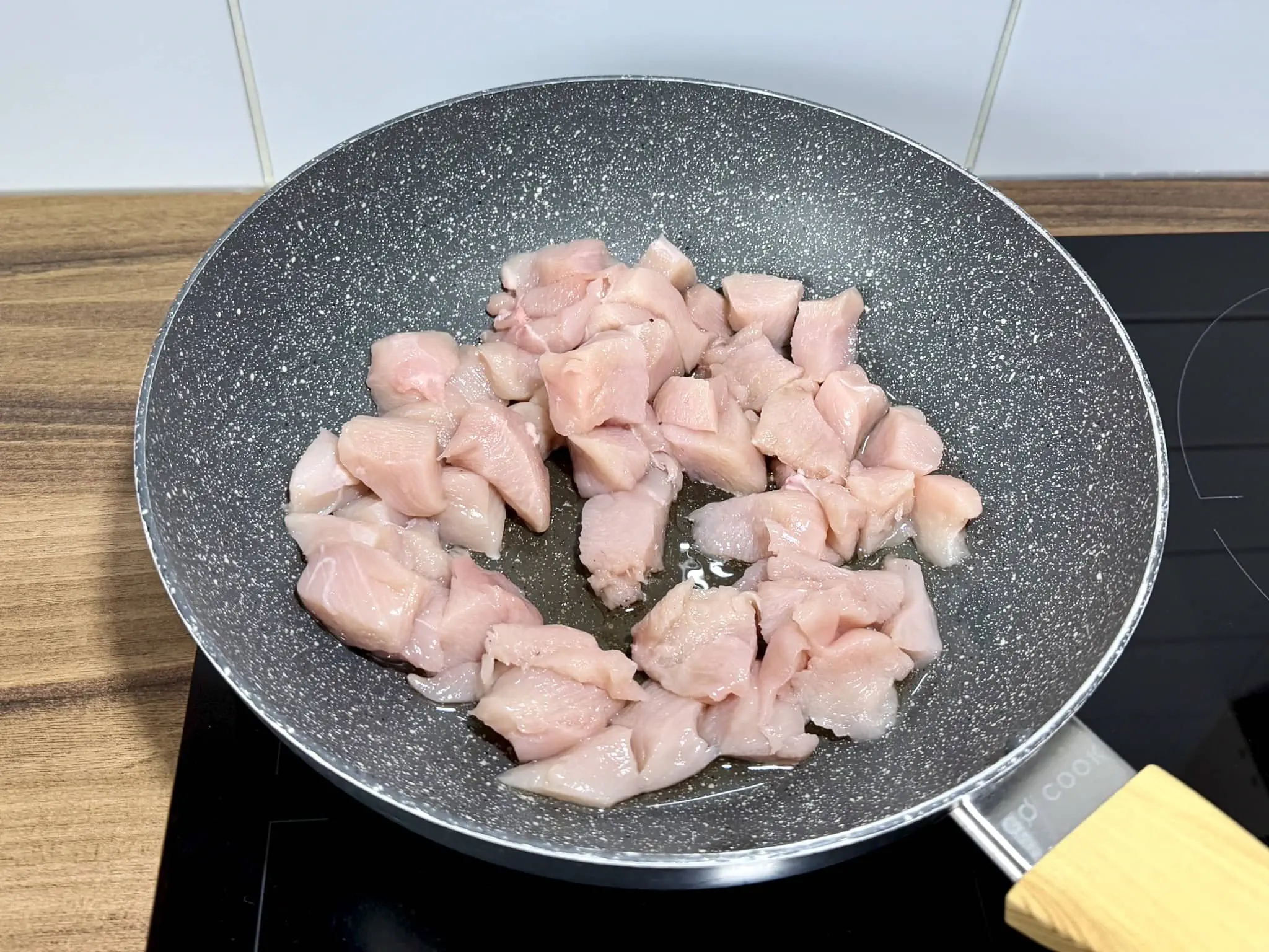 Pokrojone piersi z kurczaka smażące się na głębokiej patelni