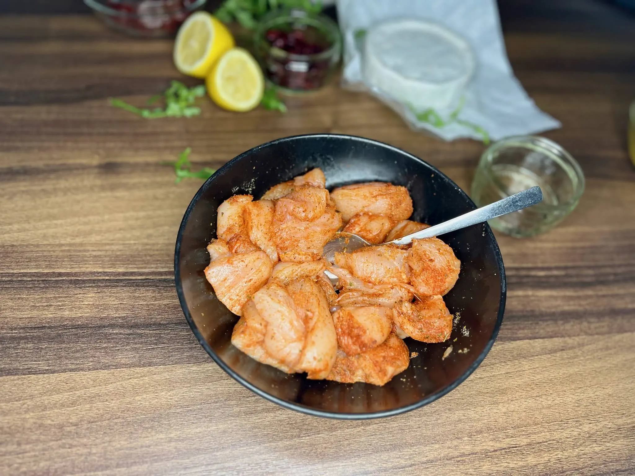 Diced chicken breast mixed with spices in a bowl