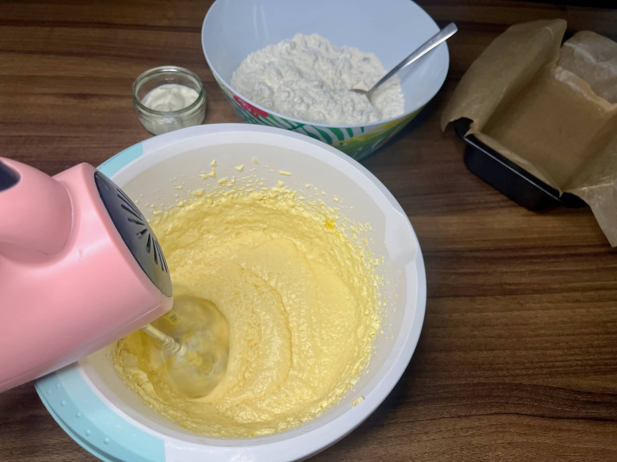 Butter mixed with icing sugar using a hand mixer in a bowl