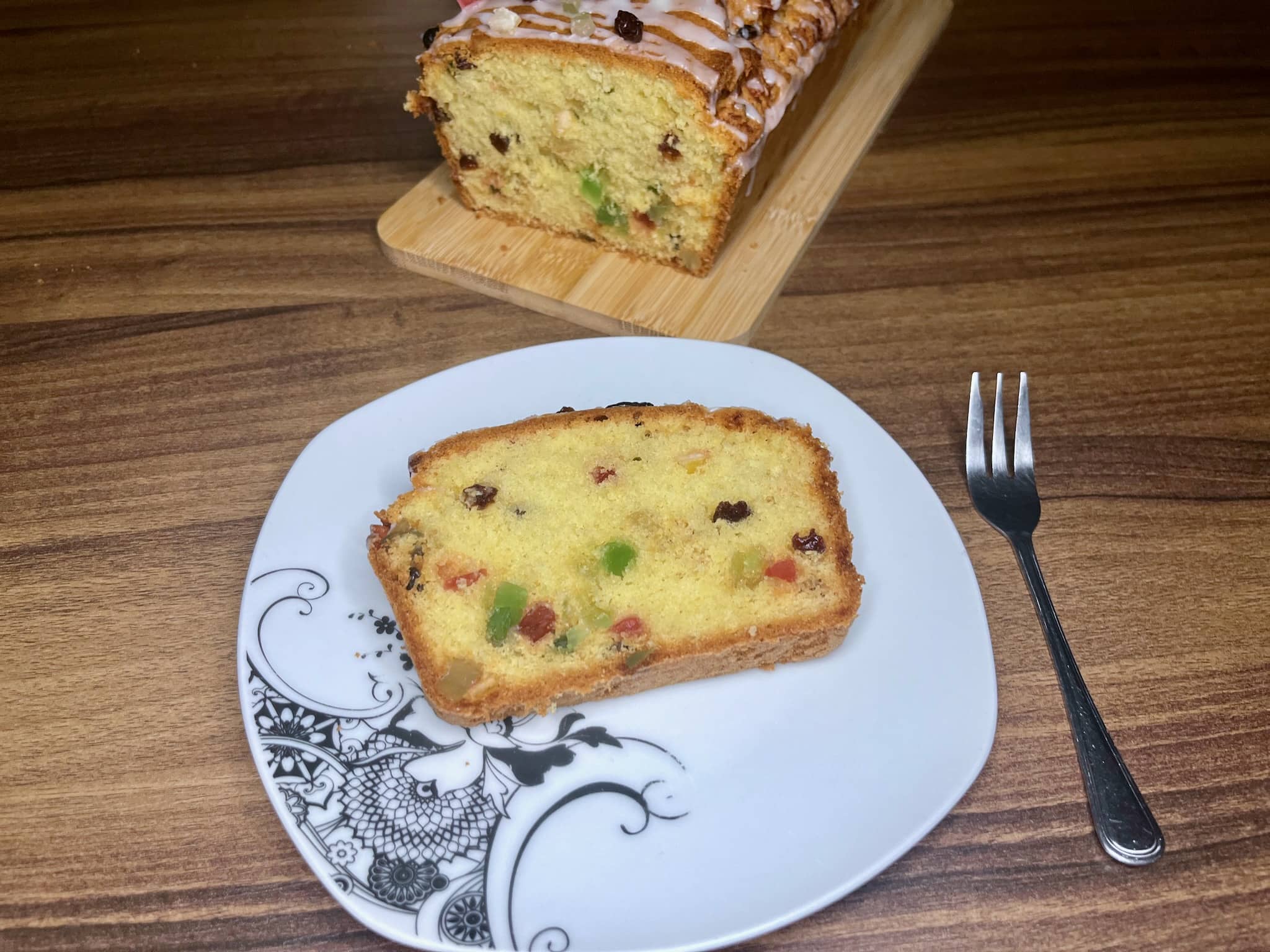 A slice of Candied Fruit Loaf Cake on a plate