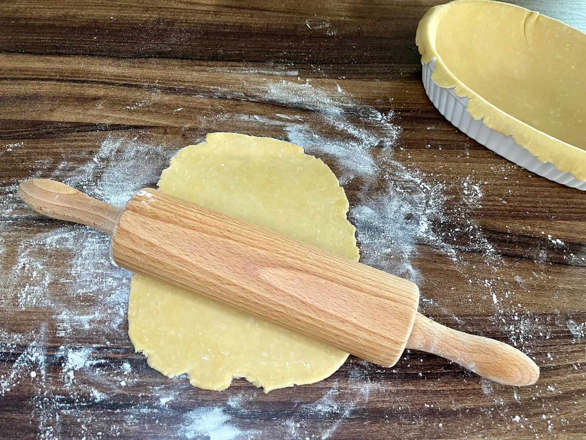 The rolled pastry on a tabletop, one lined in an ovenproof dish