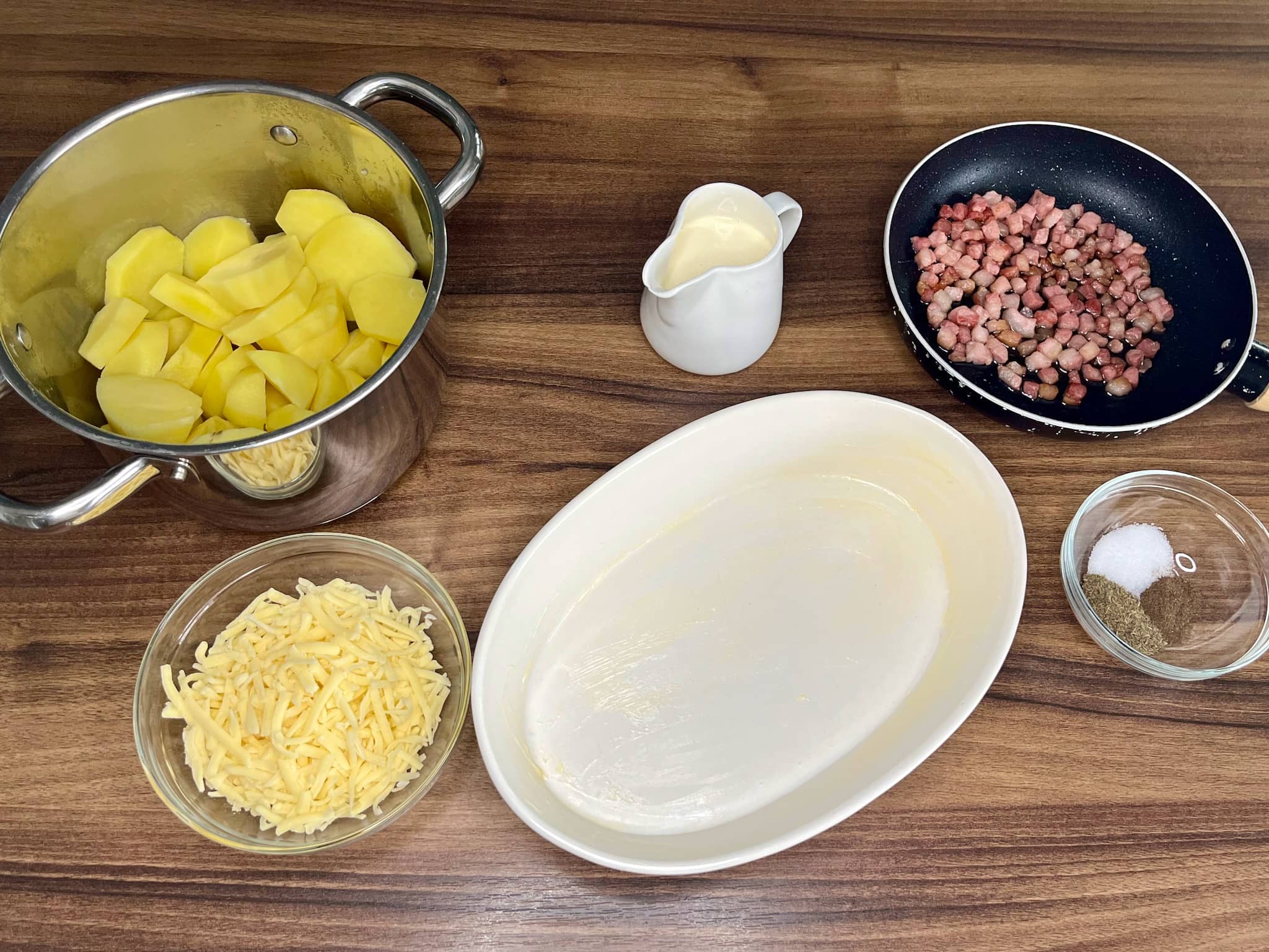 Ingredients for Cheesy Baked Potatoes with Pancetta on a tabletop