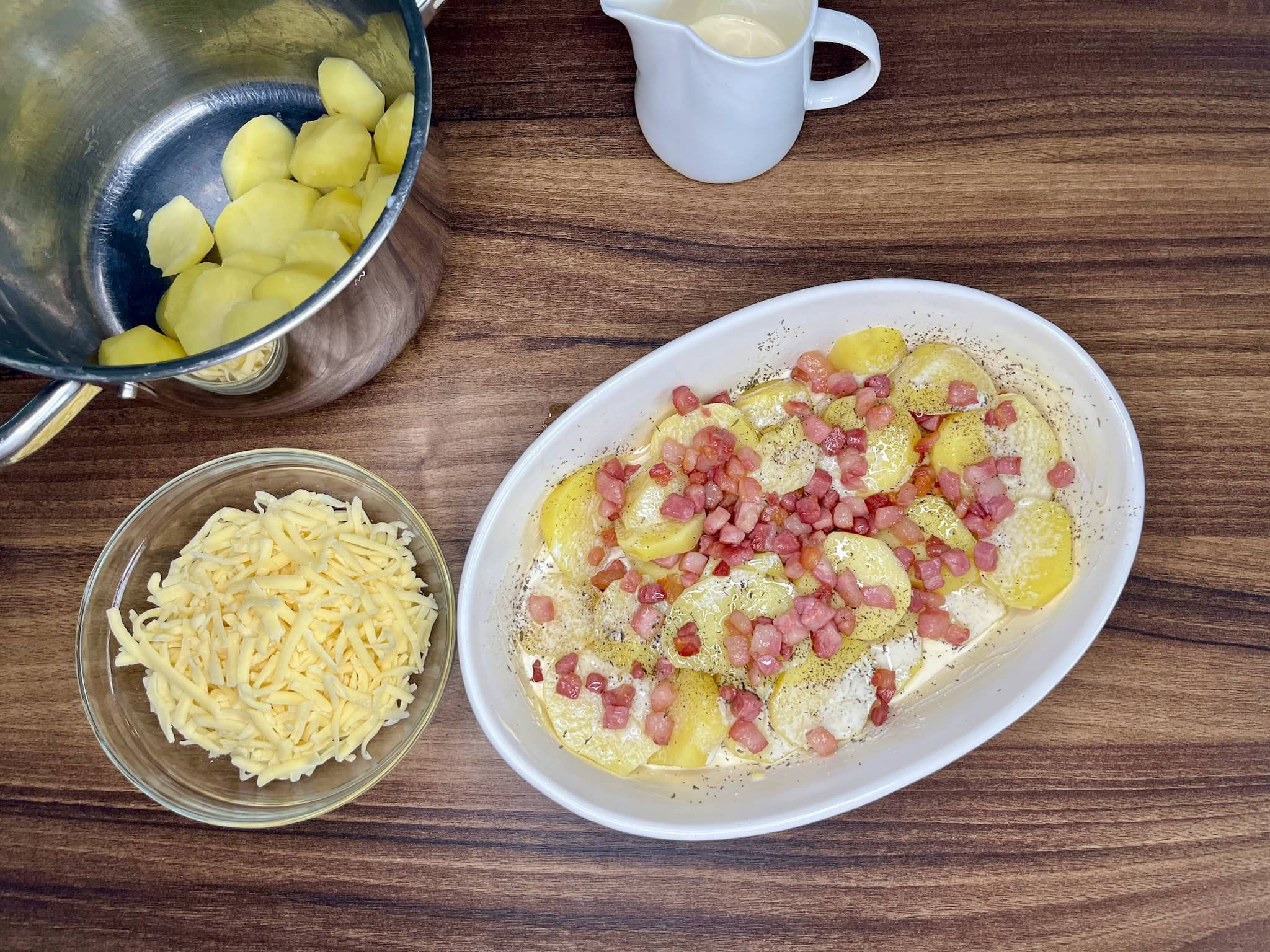 Preparing a dish for Cheesy Baked Potatoes with double cream and pancetta in a dish