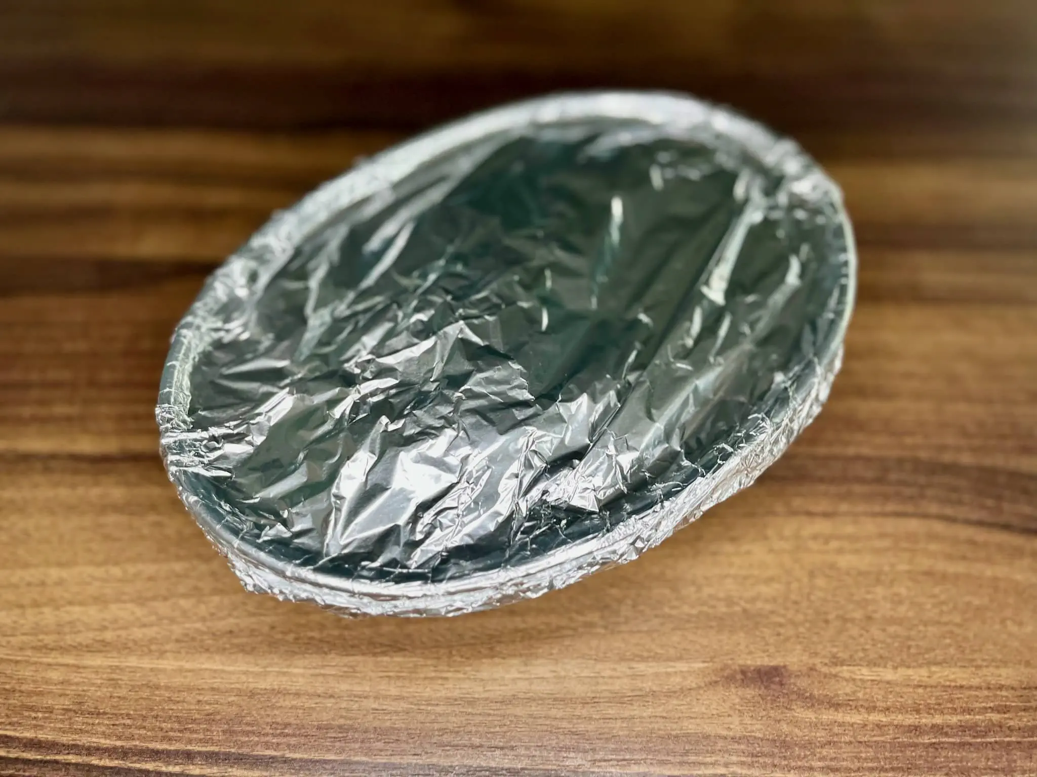 Naczynie na Zapiekankę ziemniaczaną przykryte folią aluminiową, gotowe do piekarnika