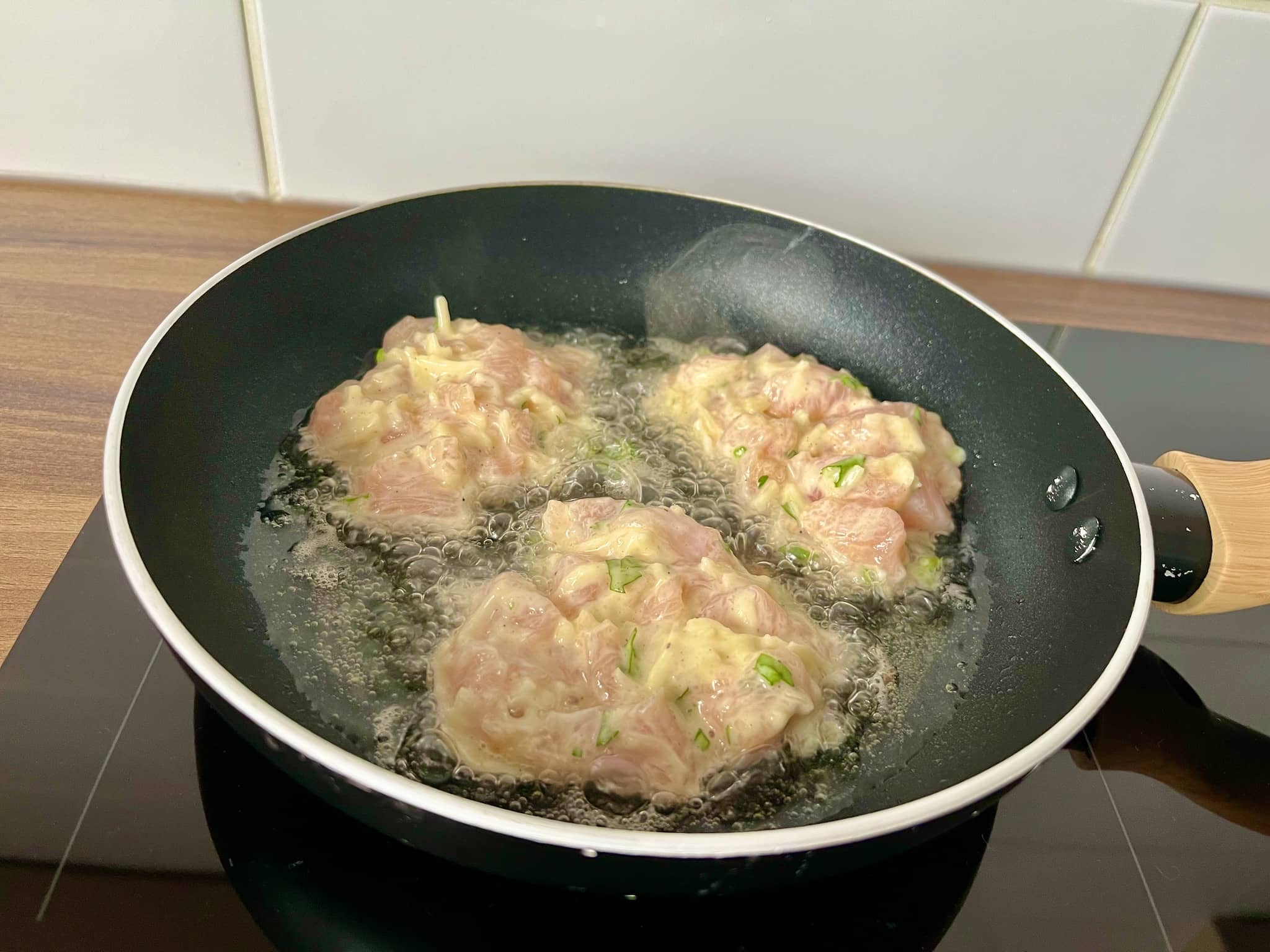 Chicken bites frying in a pan
