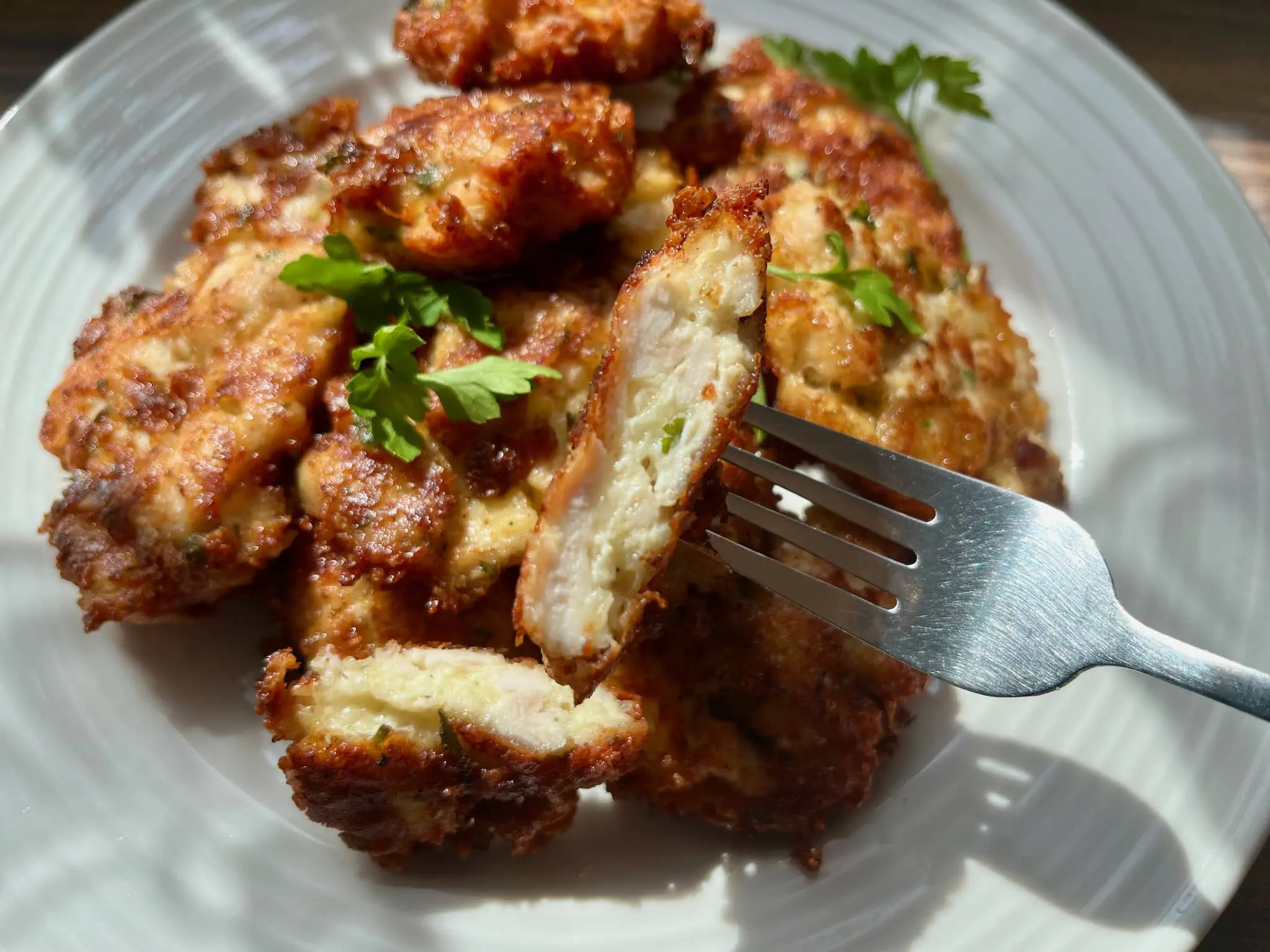 Cheesy Chicken bites on a plate, cut in half showing inside