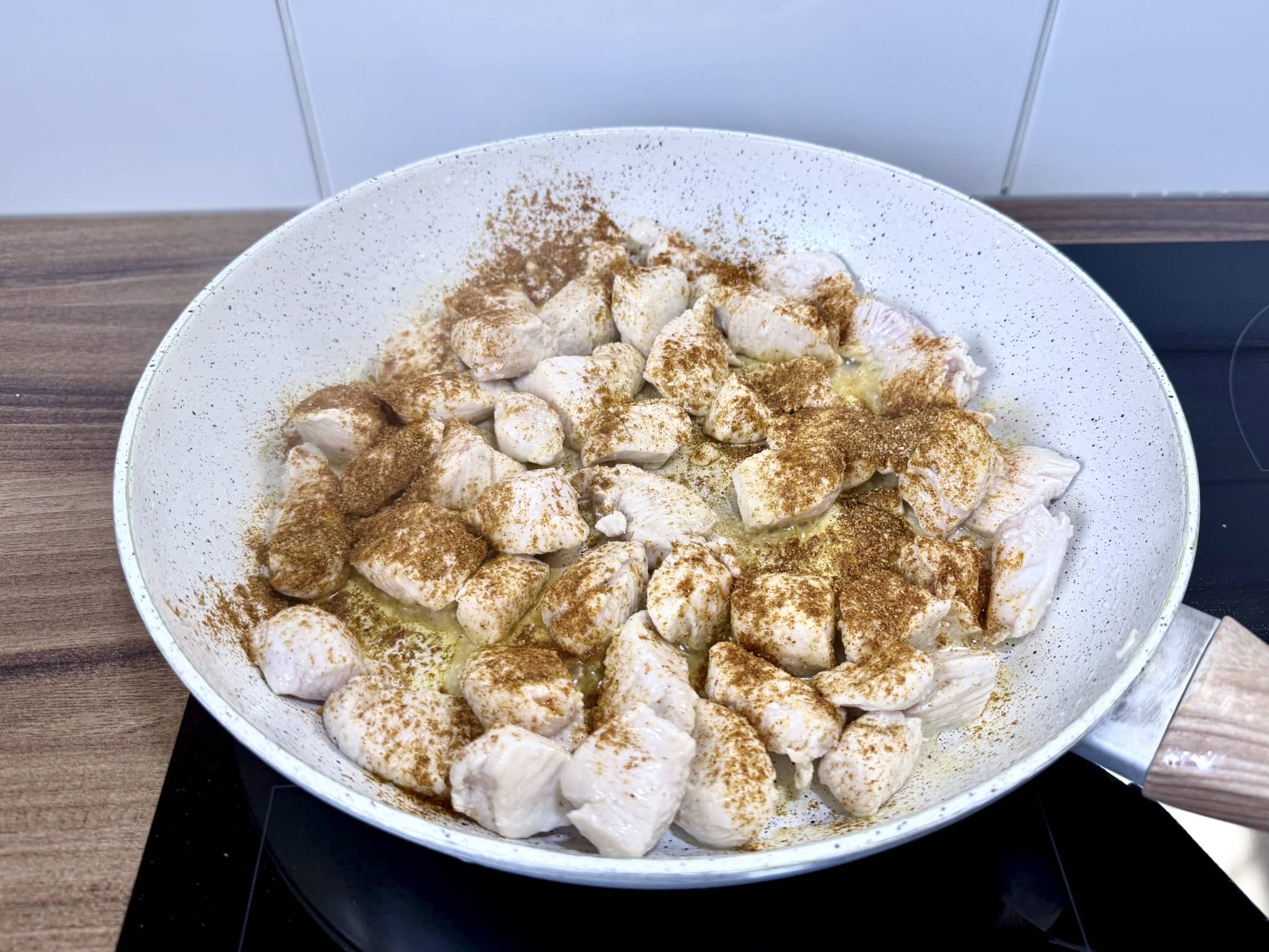Fried chicken breast pieces seasoned with seasonings in a frying pan