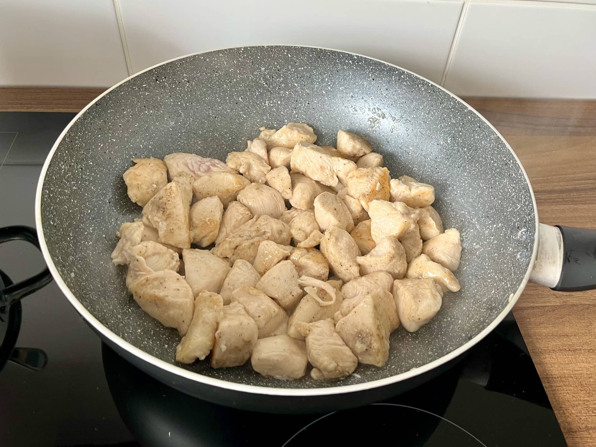 Stir-fried chicken chunks in a pan