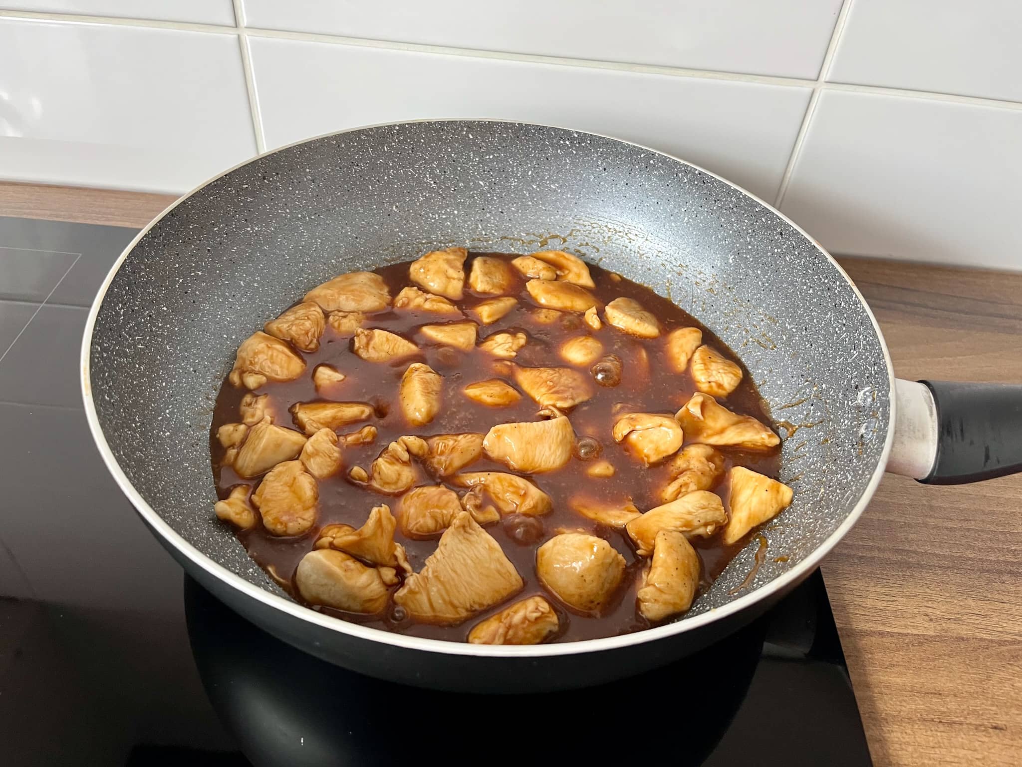 Stir-fried chicken chunks in Chinese-style BBQ Sauce in a pan