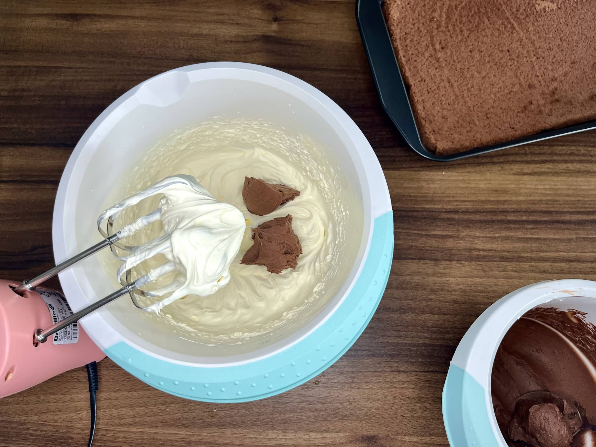 Whisking double cream in a bowl with added chocolate syrup/liqueur/cocoa powder