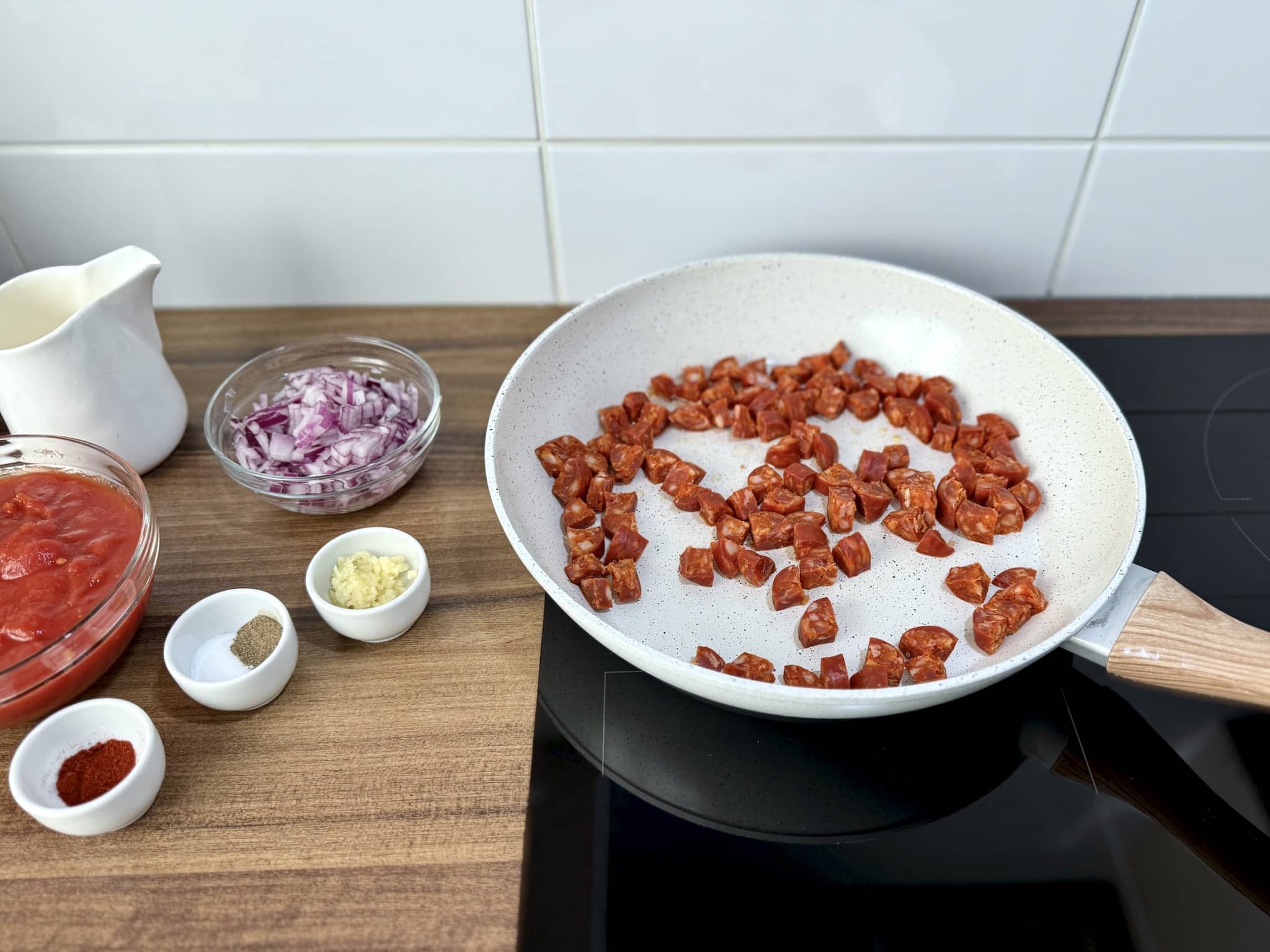 Chorizo smaży się na patelni z resztą składników po lewej stronie