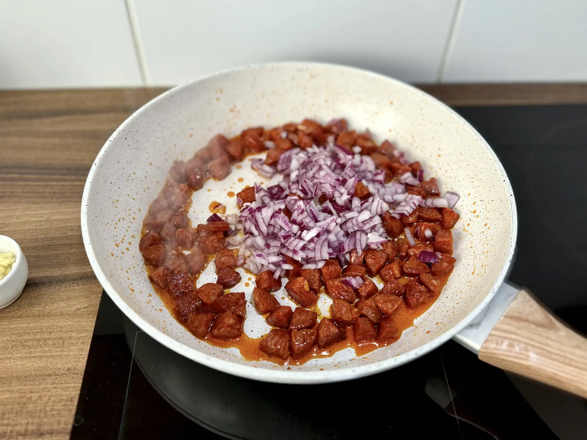 Usmażone Chorizo z posiekaną cebulą dodaną do patelni