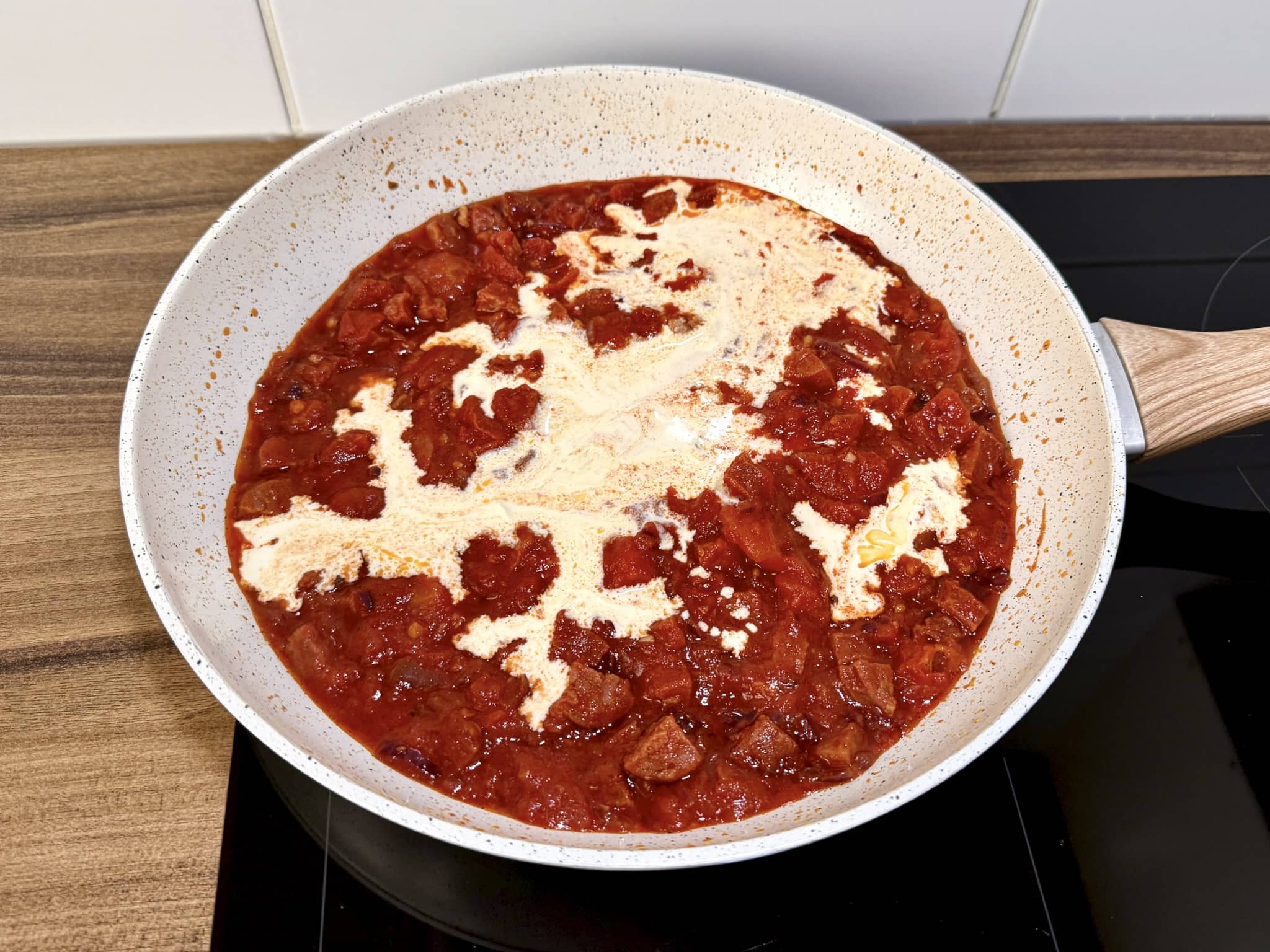 Śmietana kremówka dodana do Chorizo i pomidorów na patelni