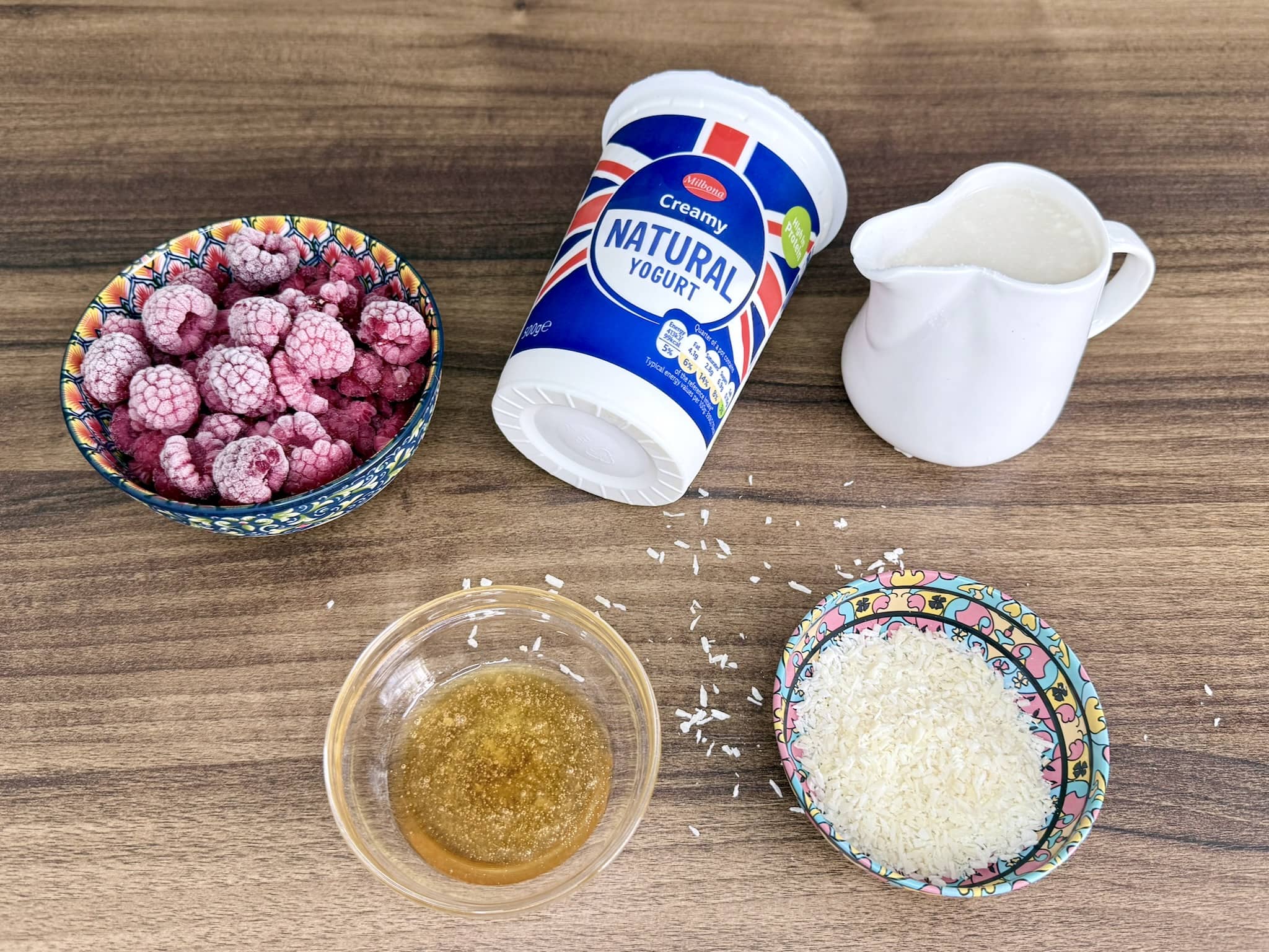Ingredients spread out on a tabletop, ready to make Coconut and Raspberry Smoothie