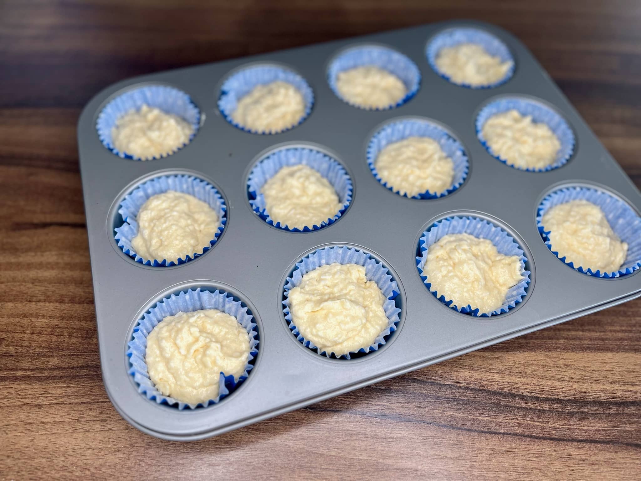 The coconut muffin mix was poured into the muffin tin.