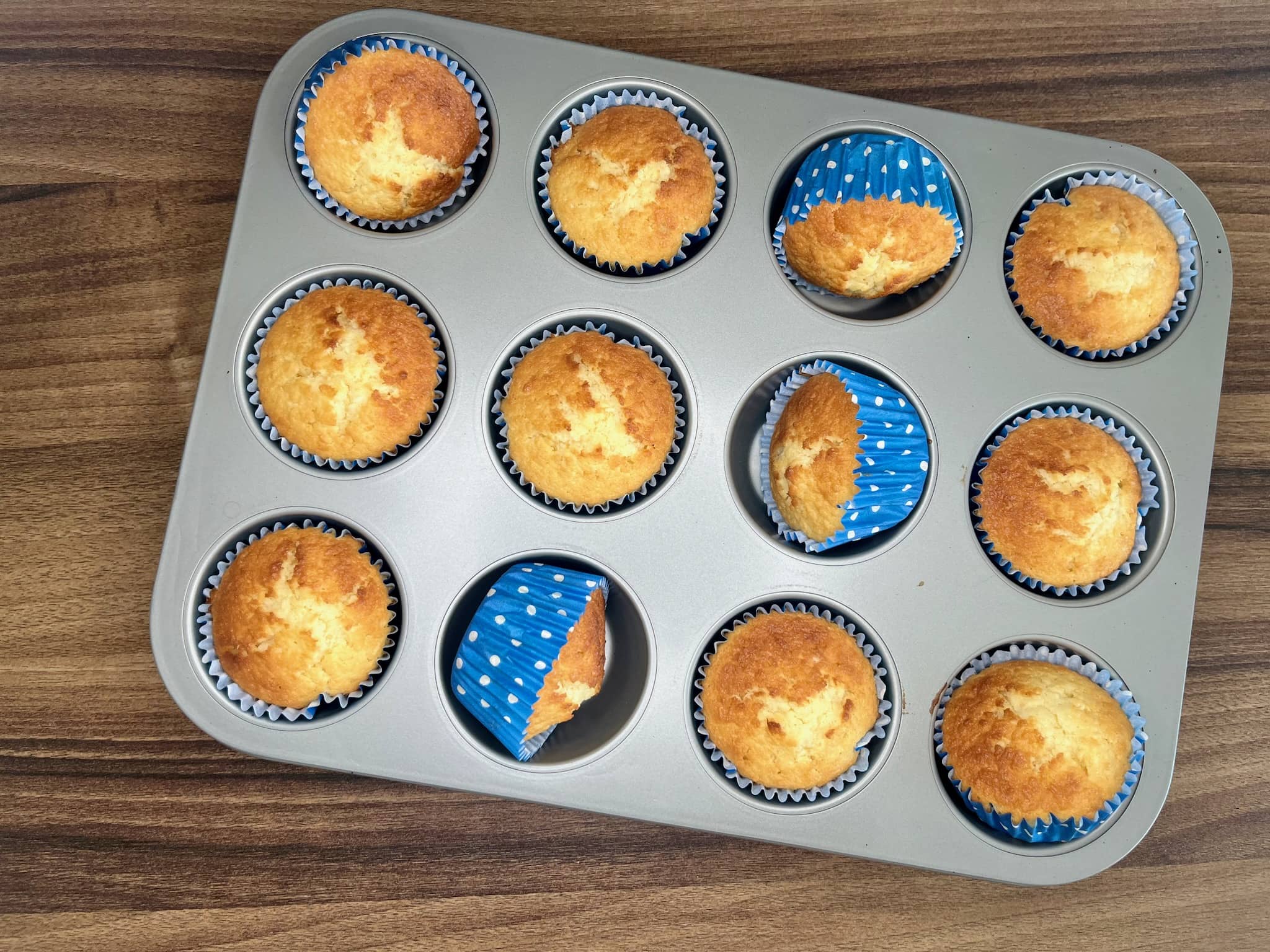 The coconut muffins are still in the tin after baking.