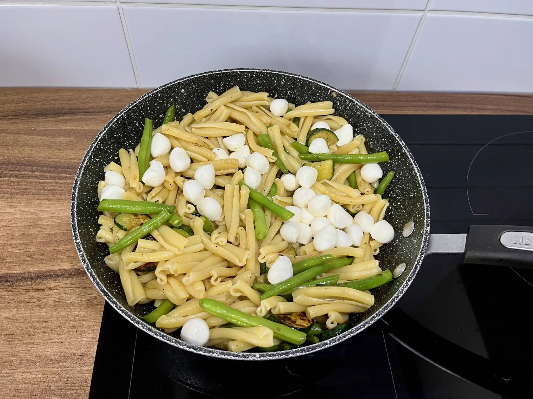 Cukinia i fasolka szparagowa z makaronem i mozzarellą na patelni