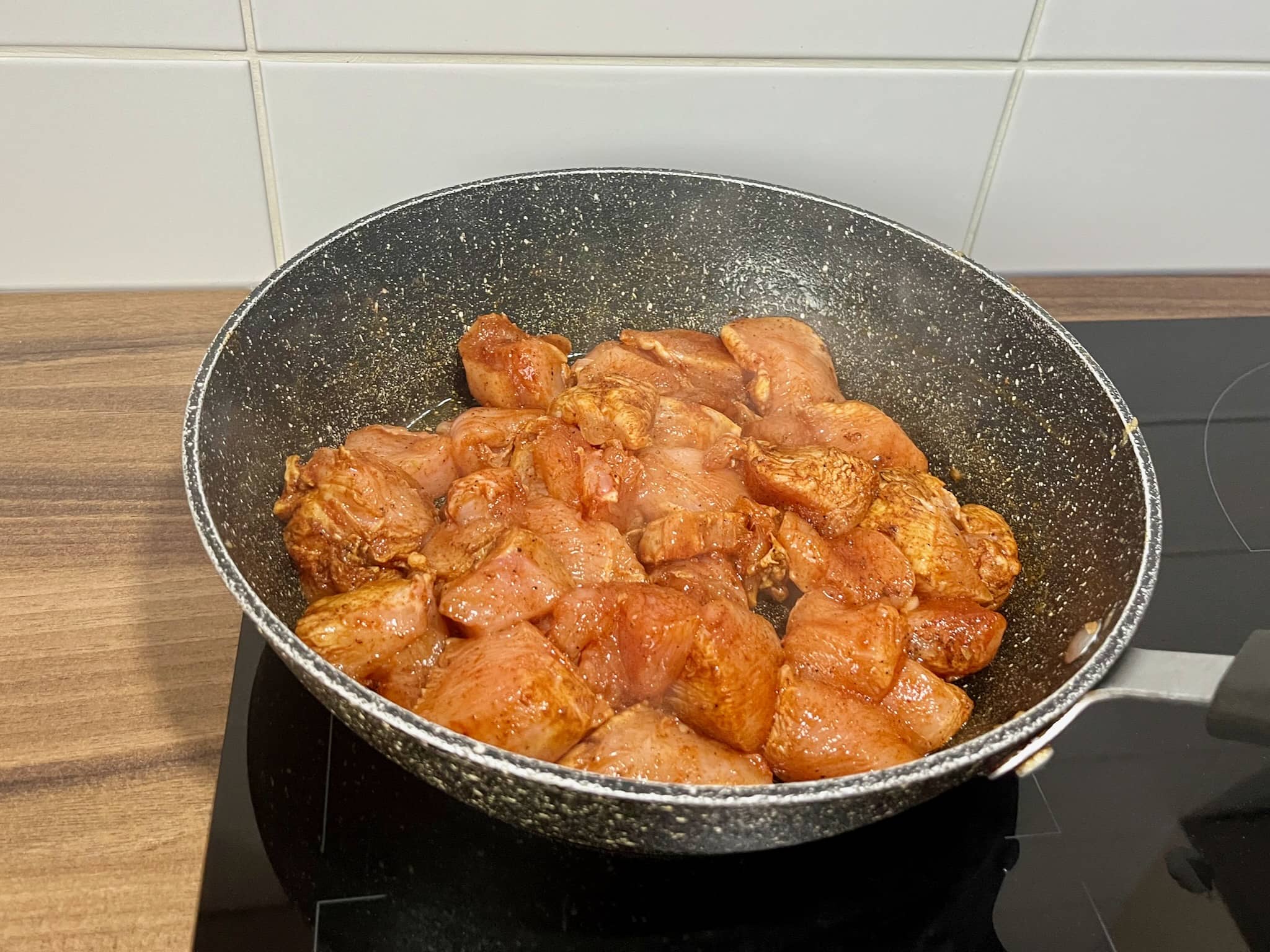 Diced chicken frying in a pan