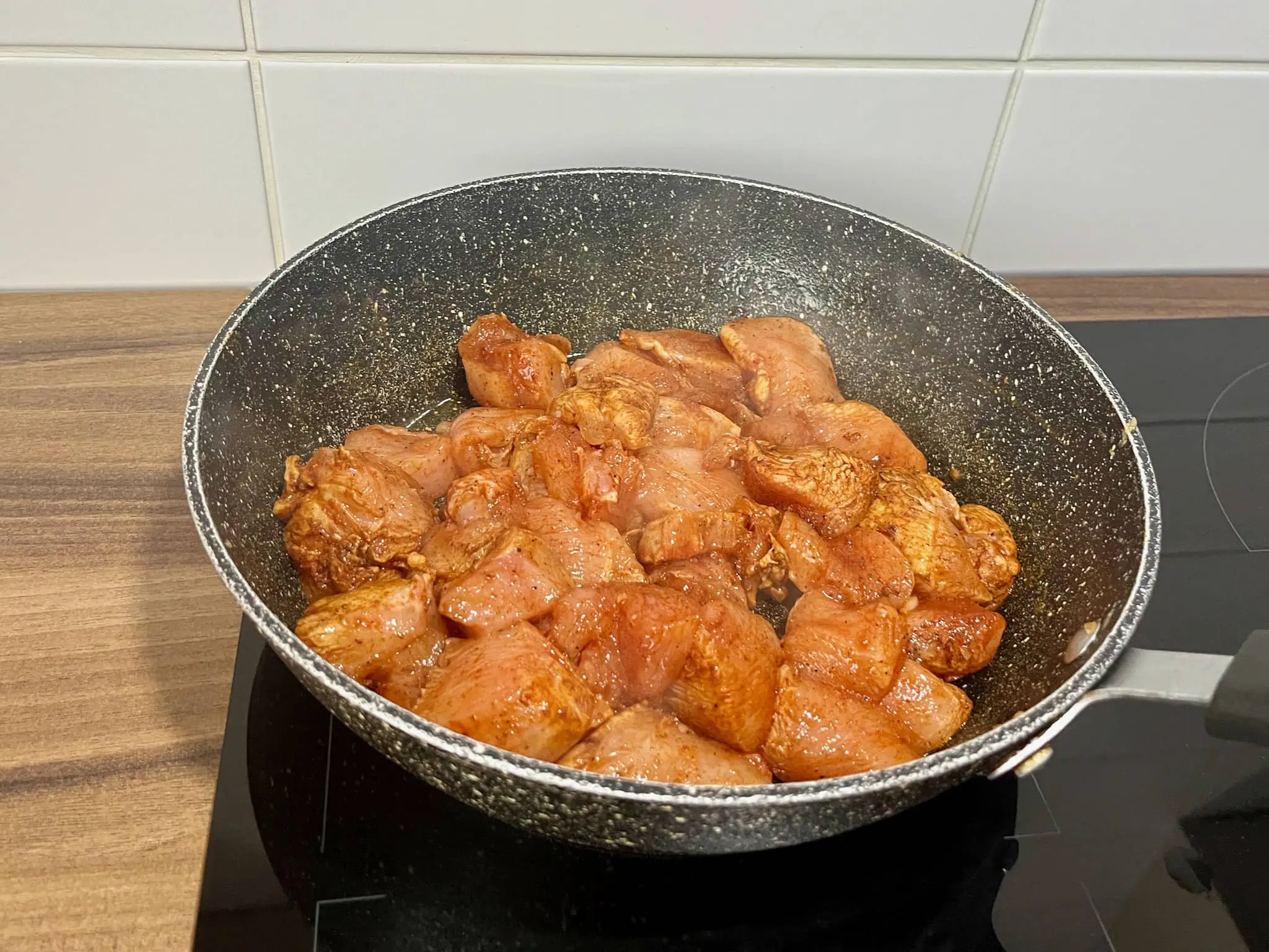 Pokrojony kurczak smażący się na patelni