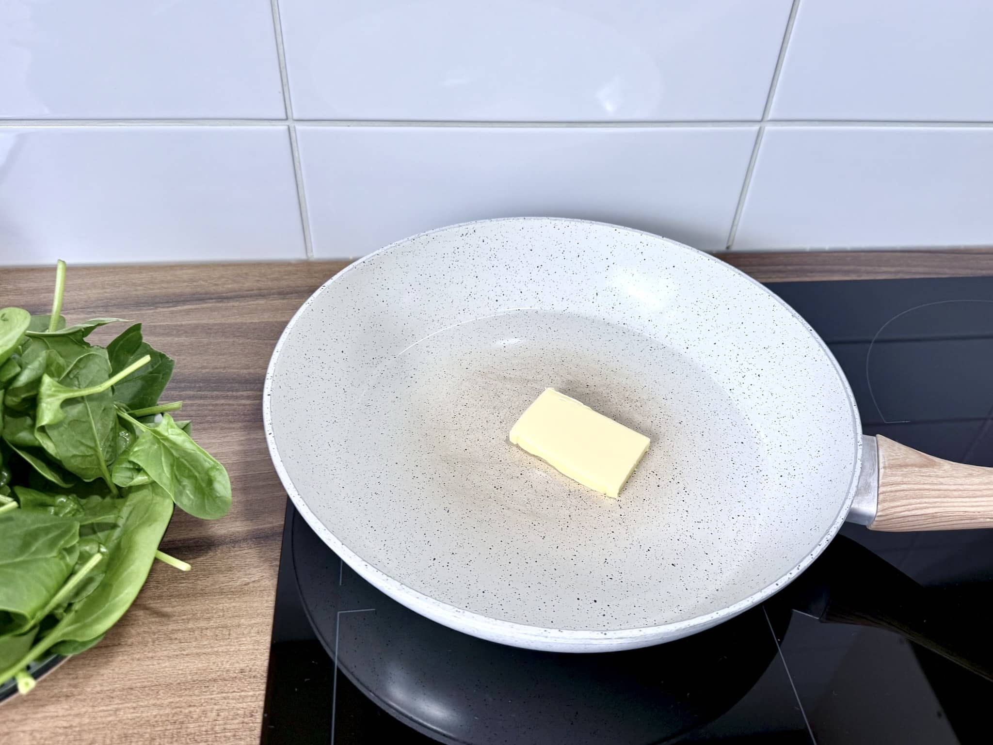 A knob of butter melting in the centre of the pan