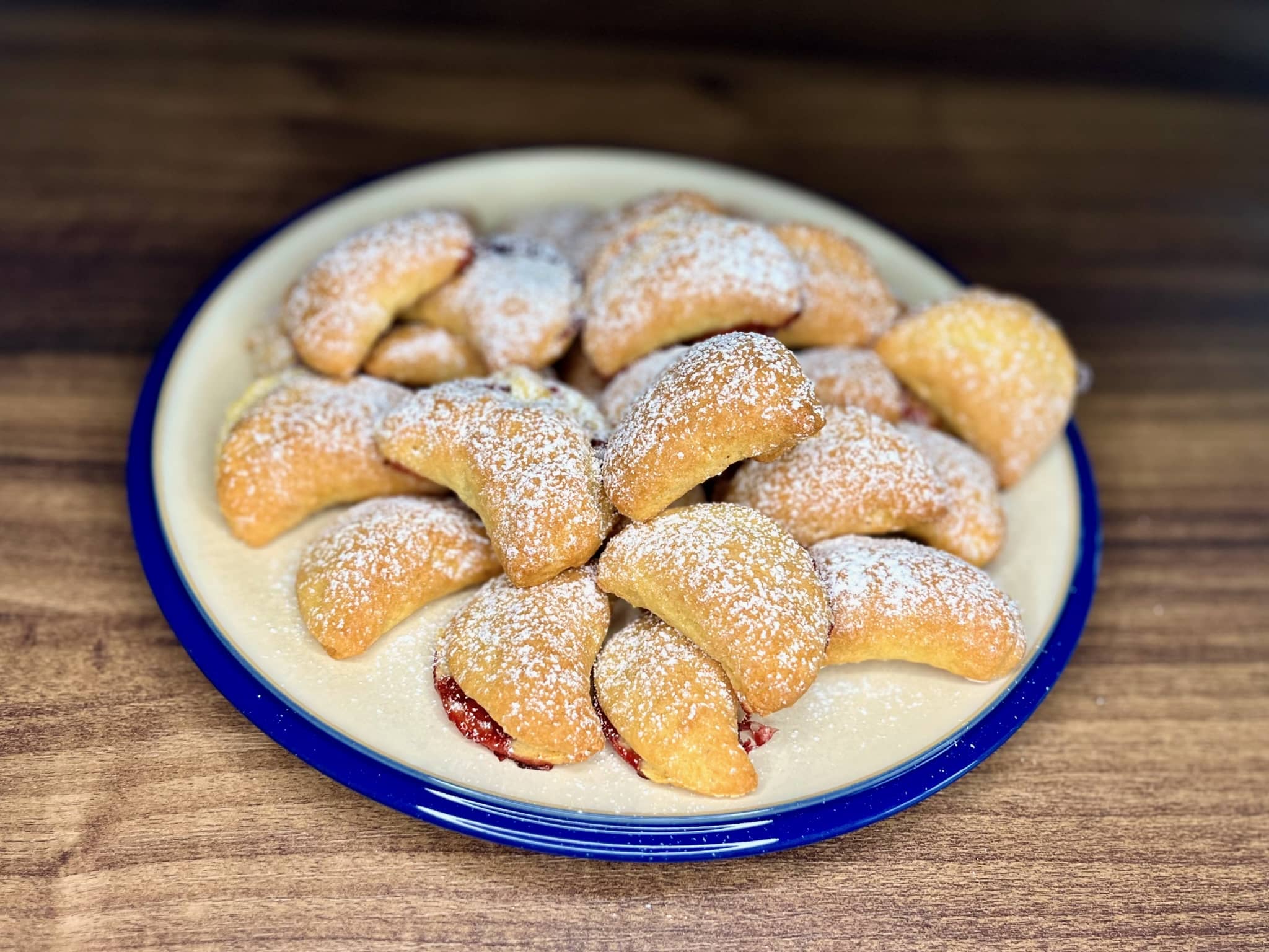 Crispy Cookies with Jam dusted with icing sugar on a plate