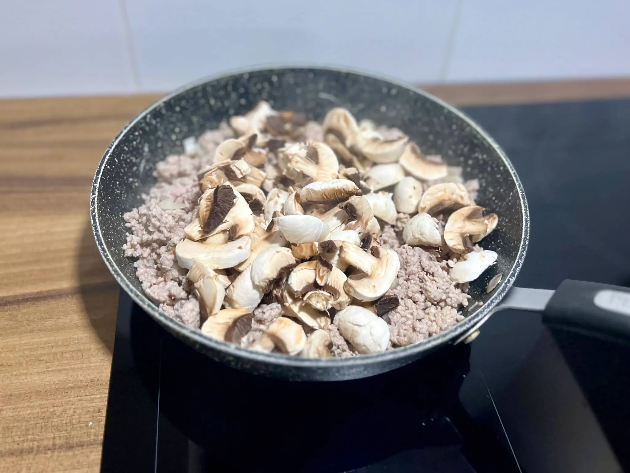 Smażenie mielonego mięsa z cebulą, czosnkiem i pieczarkami