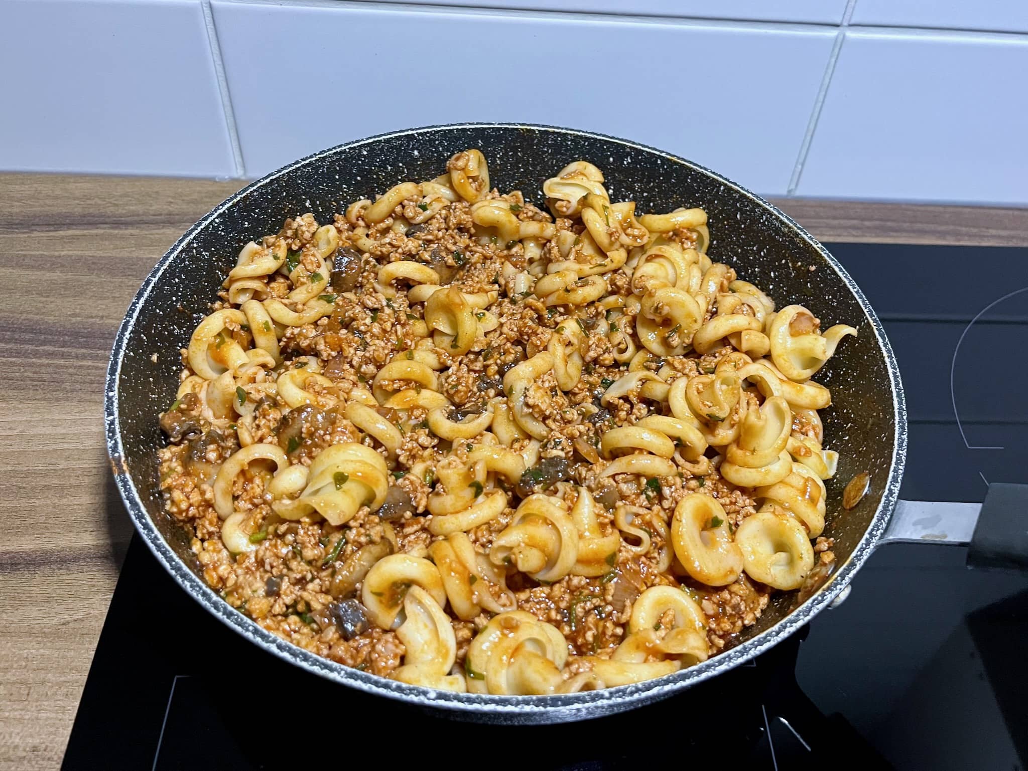 Tomato-pork sauce mixed with Vesuvio pasta before serving